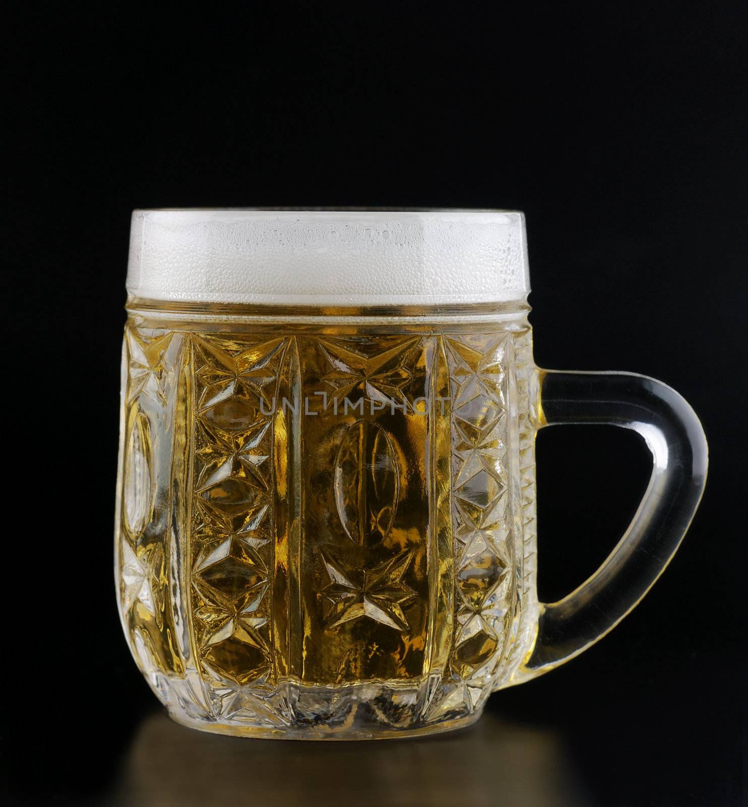 crystal cup of beer on a black background with the foam poured around