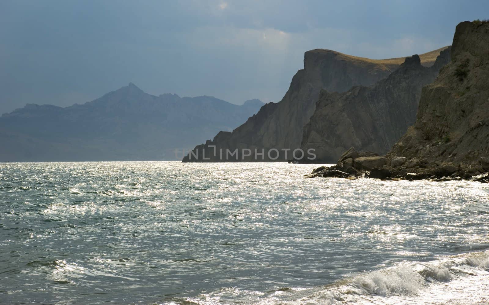 The storm sky above ocean on a background of picturesque mountains