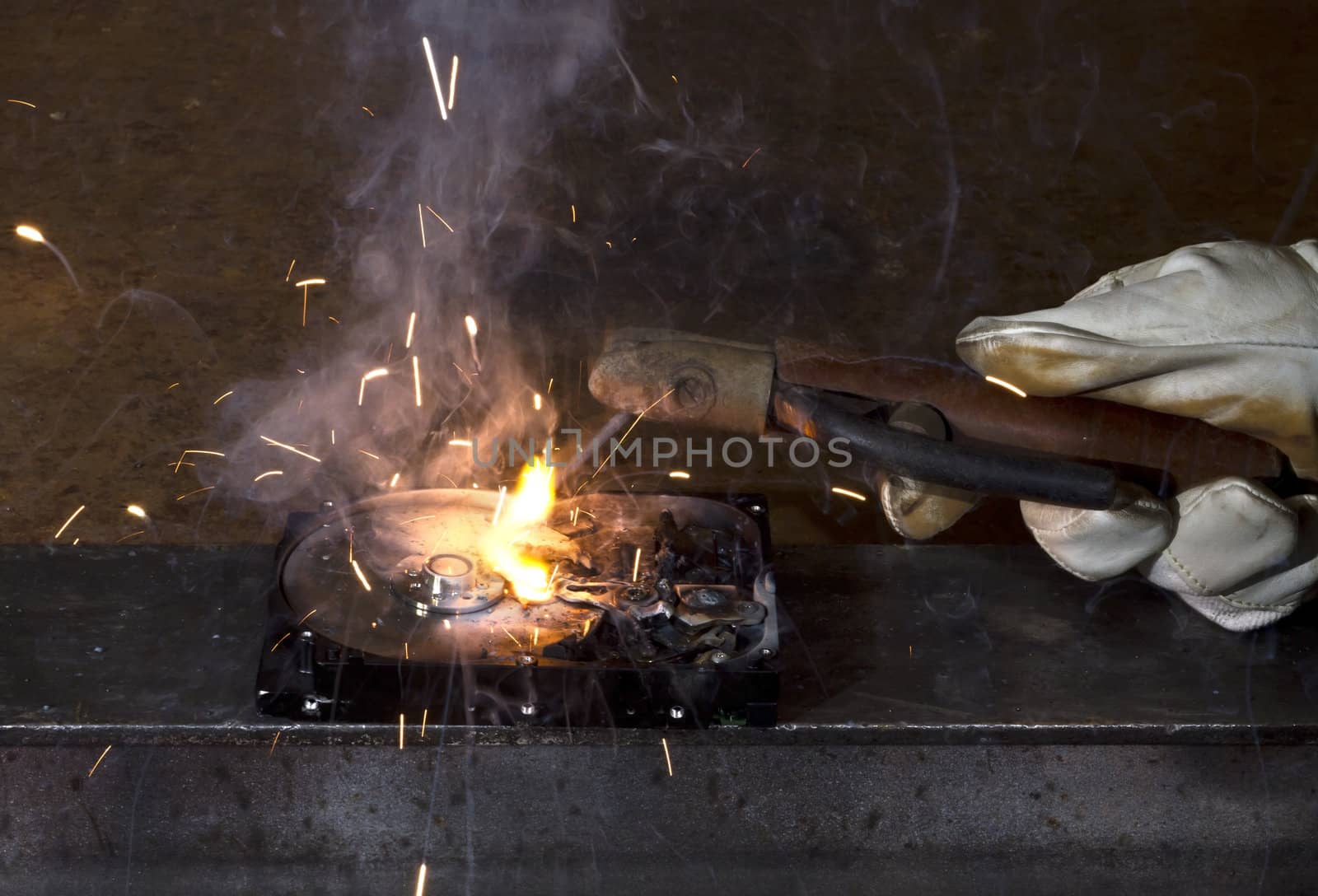 welding on open hard disk drive in dark rusty background. sparks flying away