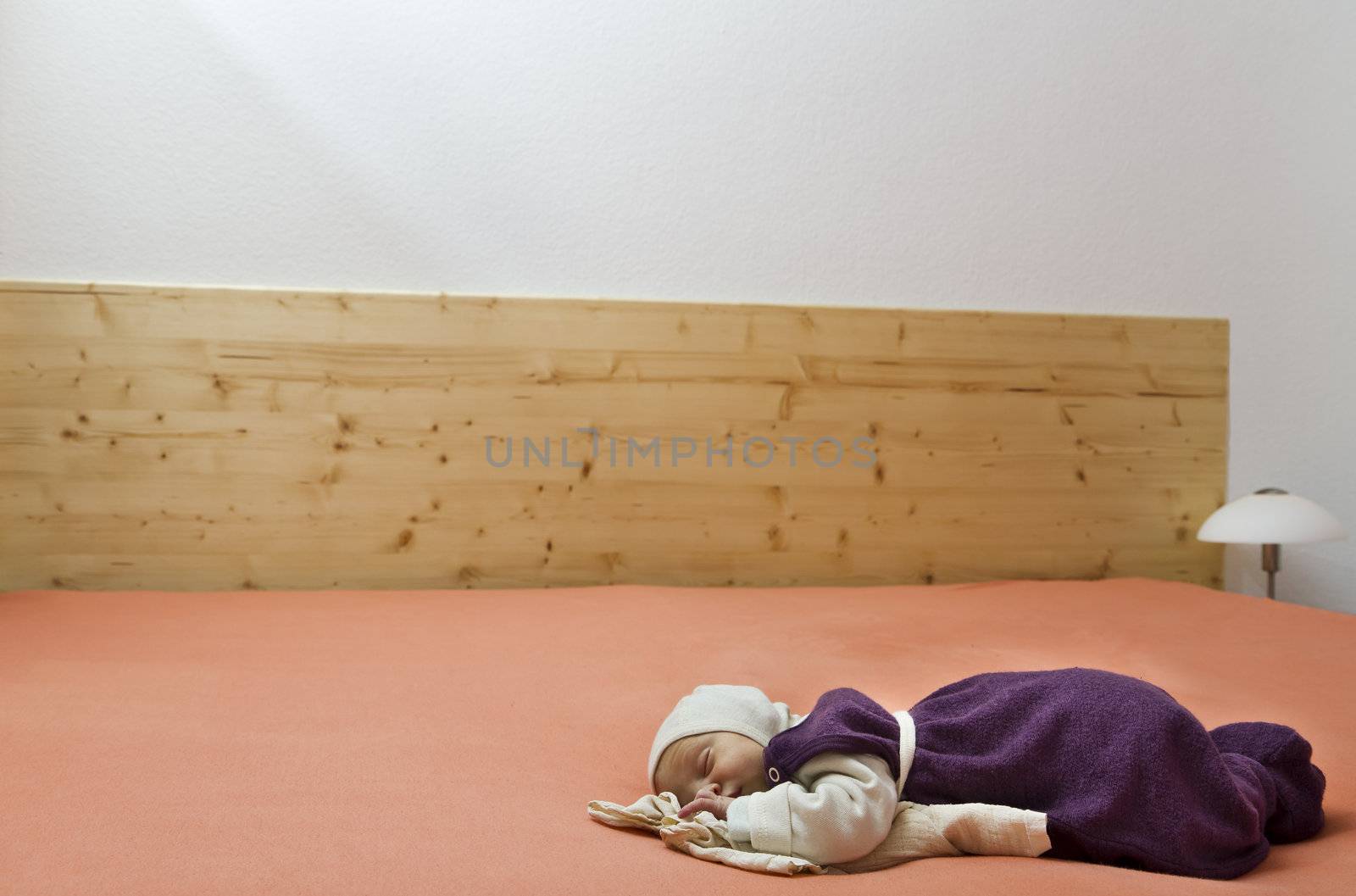 sleeping suckling alone in huge bed with wooden end