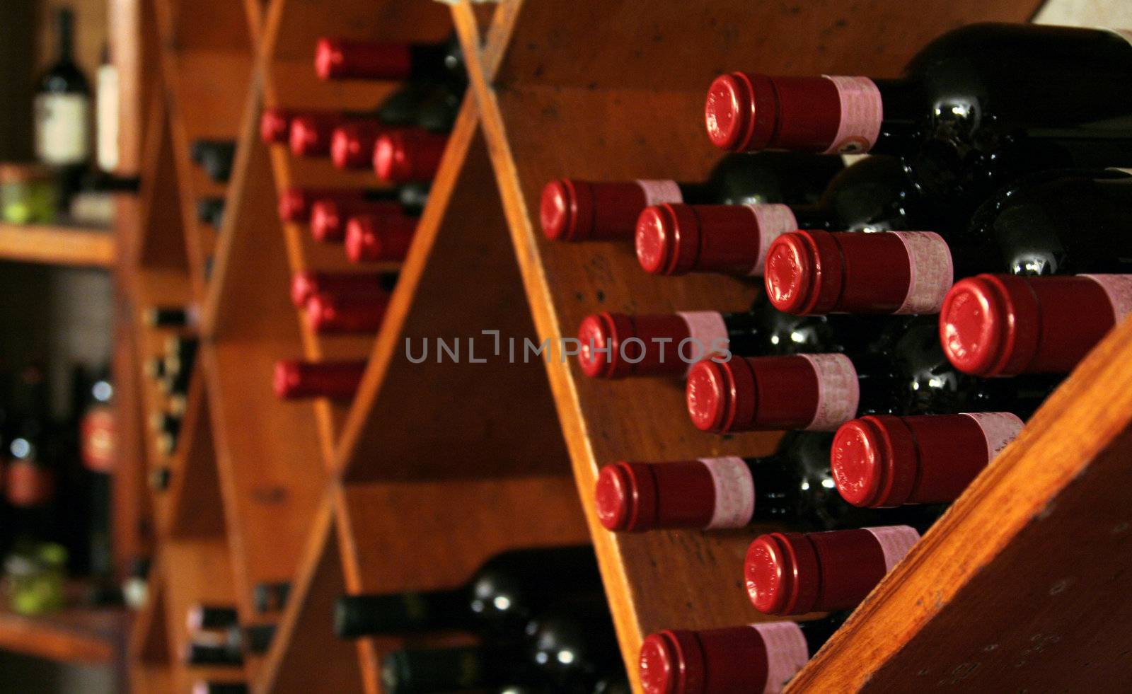 A buch of wine bottles in a rack in a wine cellar.