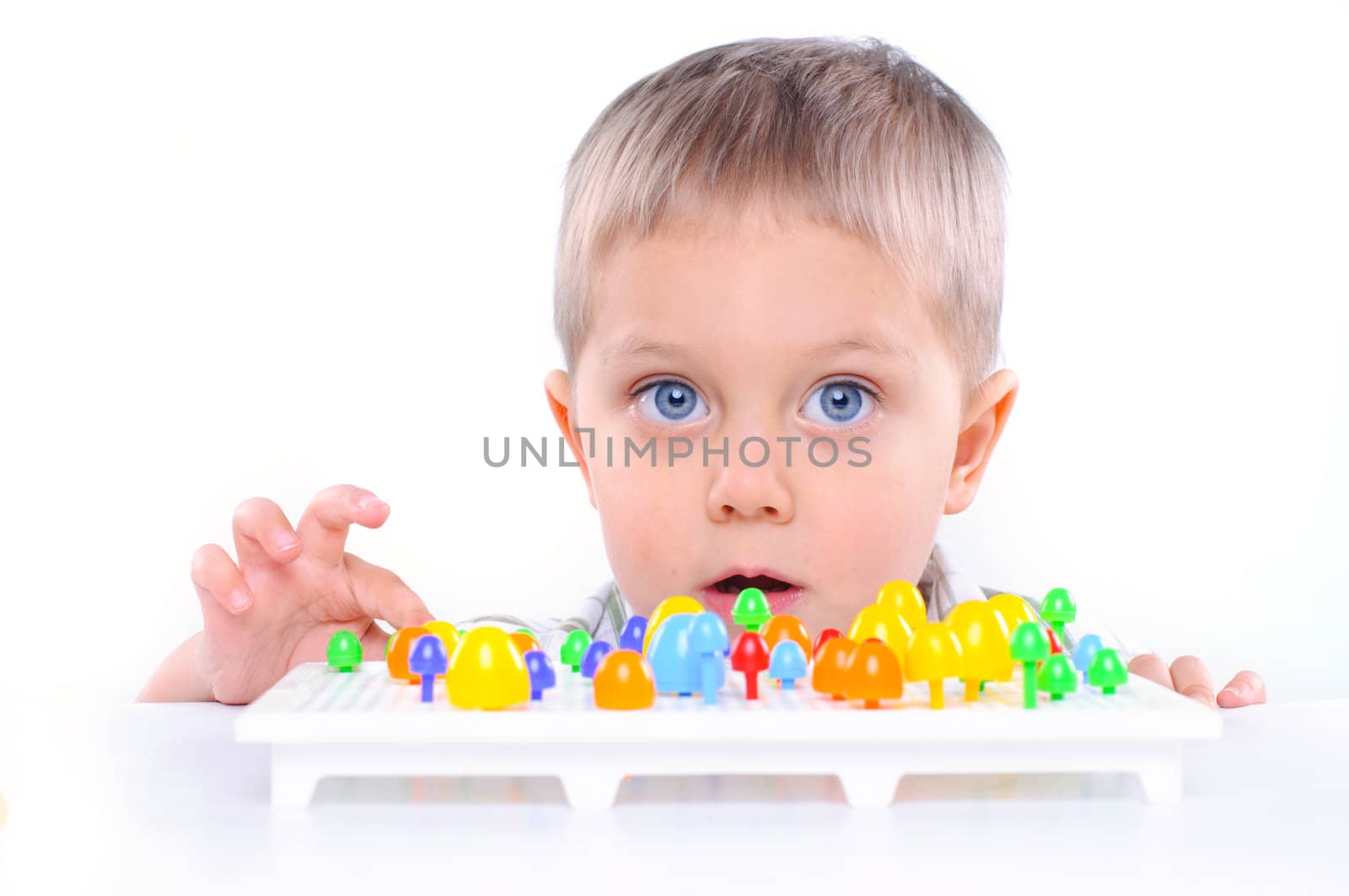 little boy playing with multicolored mosaic isolated on a white background