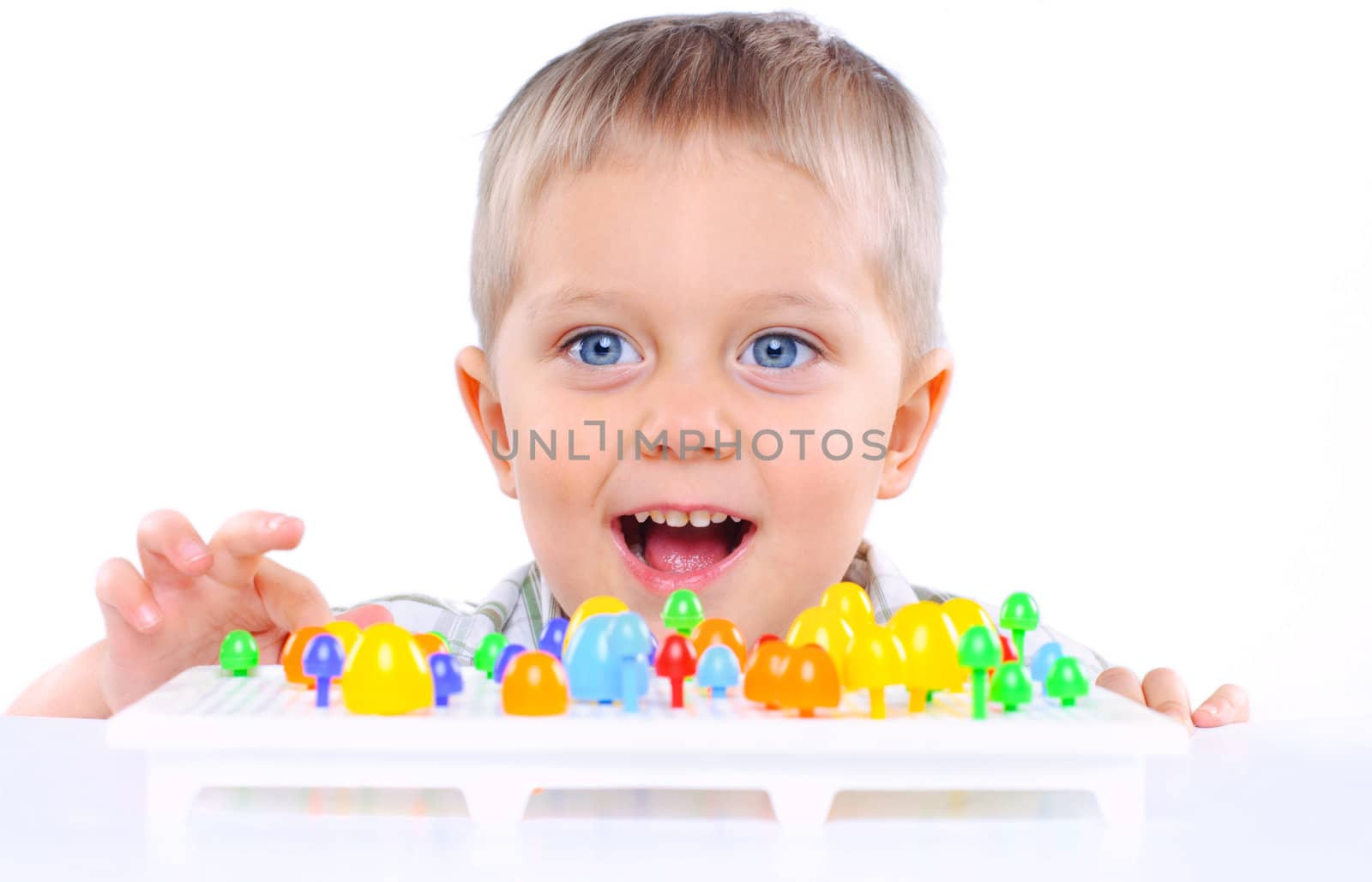 little boy playing with multicolored mosaic isolated on a white background