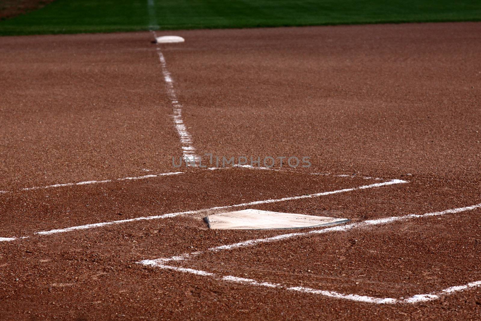 The view down the left field line with home plate and the batters boxes in focus.