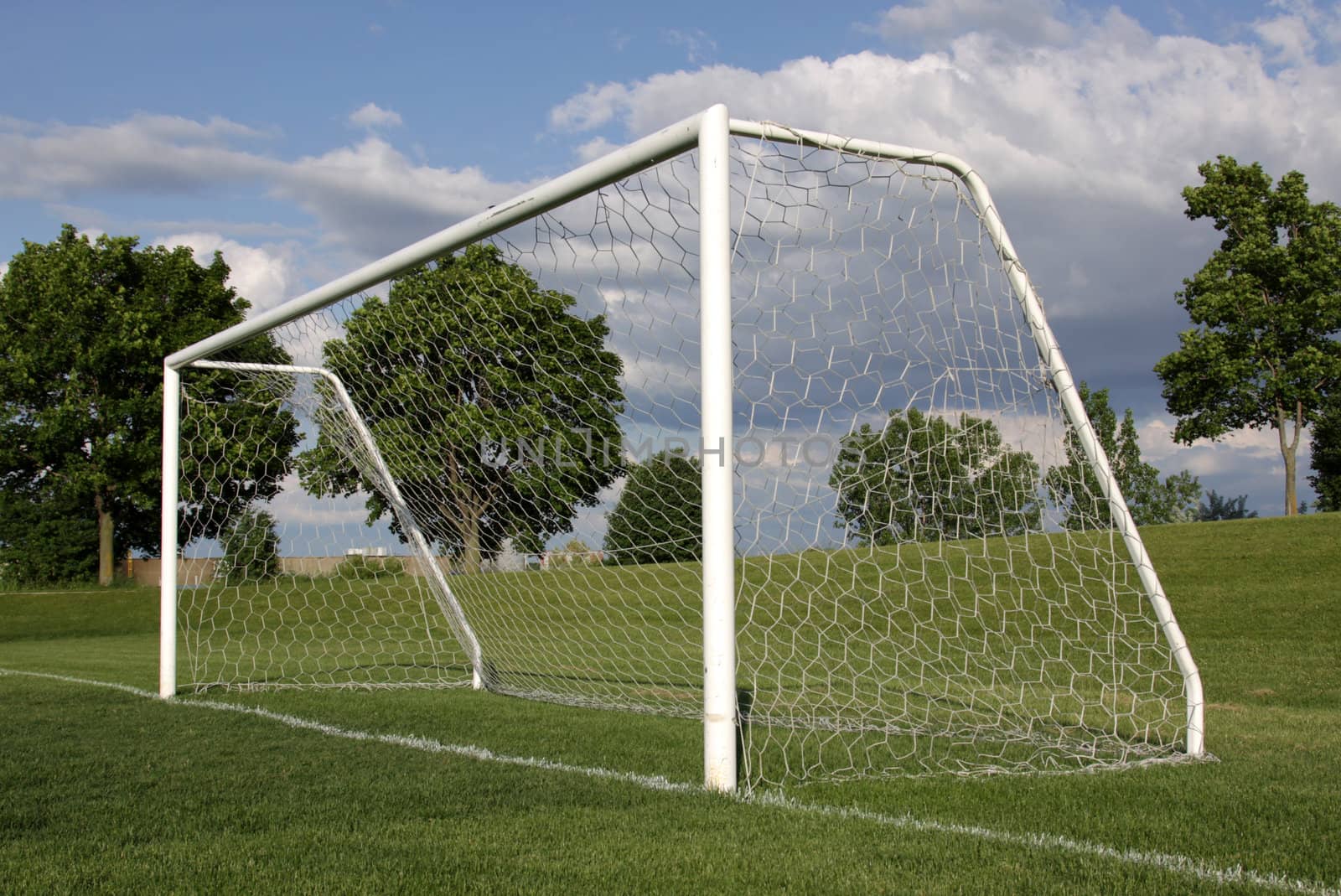 A view of a net on a vacant soccer pitch.
