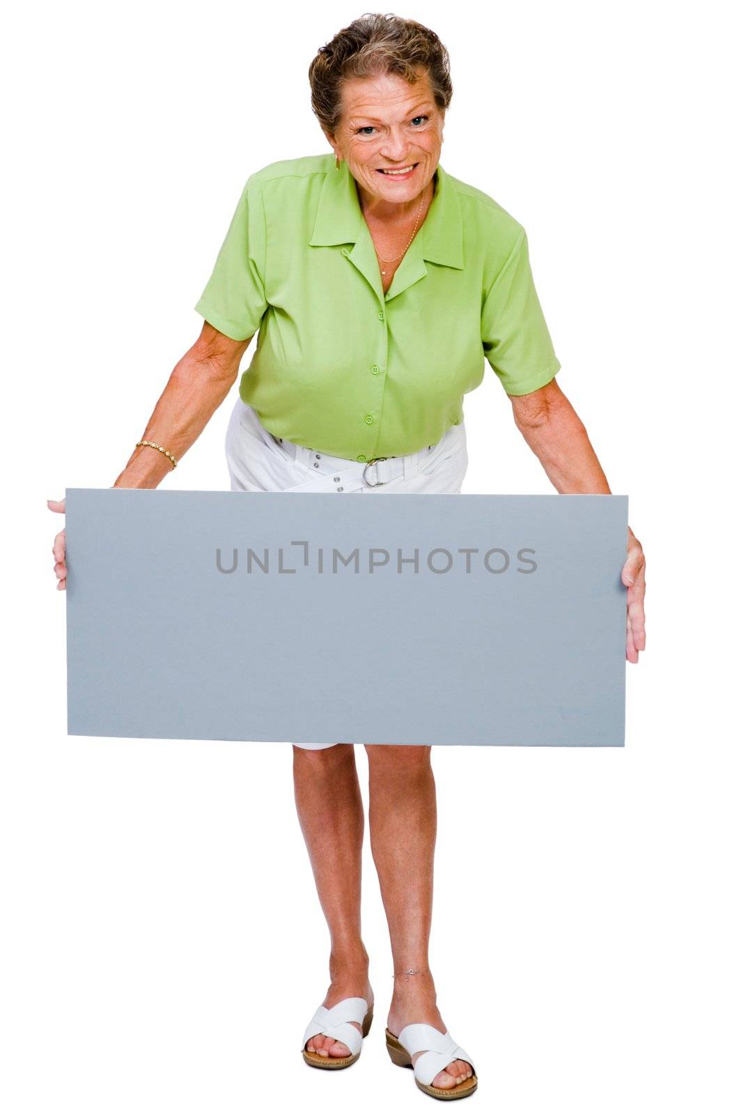 Mature woman showing a placard and smiling isolated over white