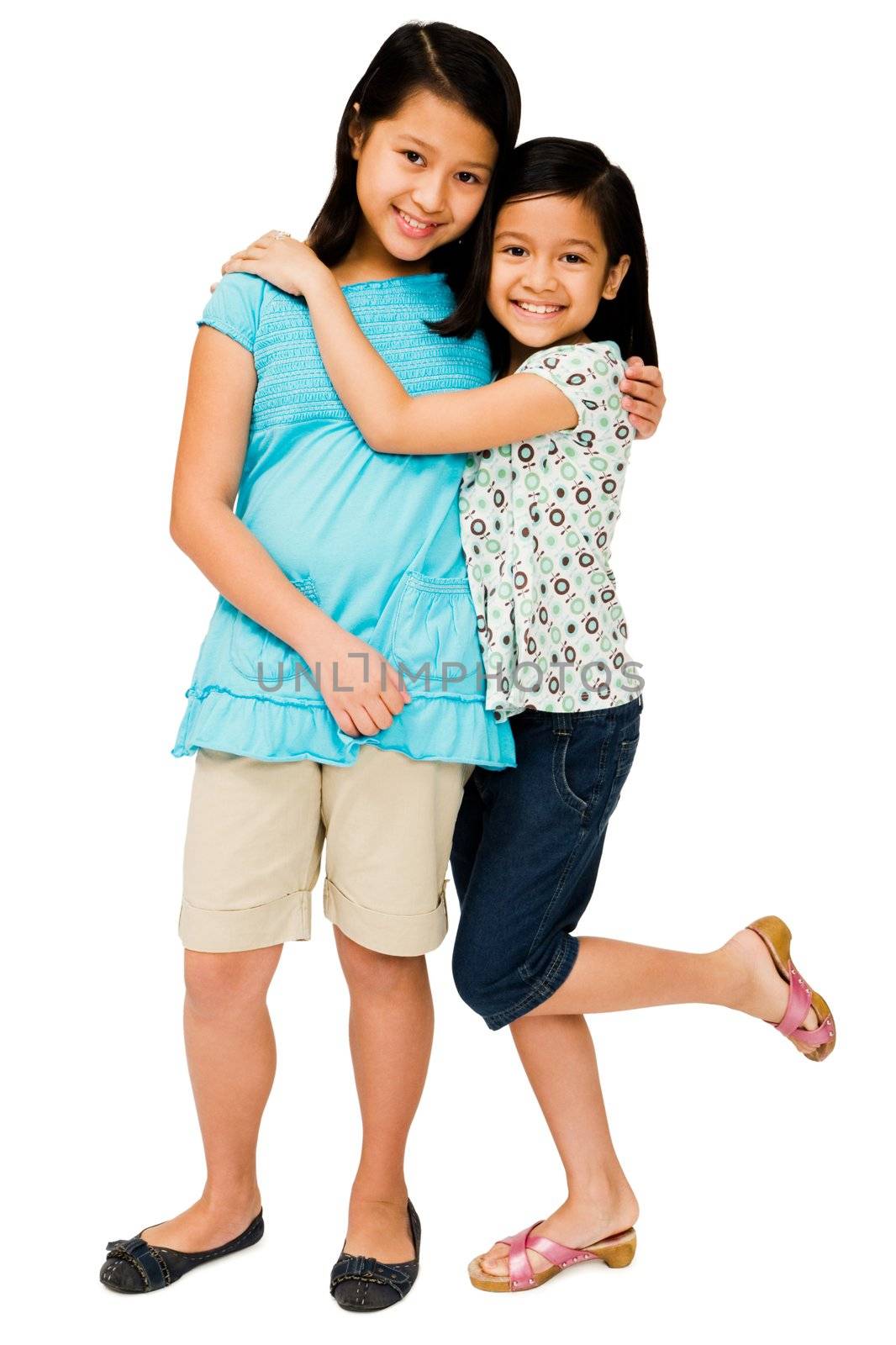 Close-up of two girls hugging each other and smiling isolated over white