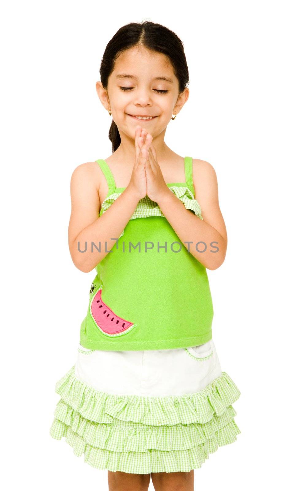 Girl standing in prayer position and smiling isolated over white