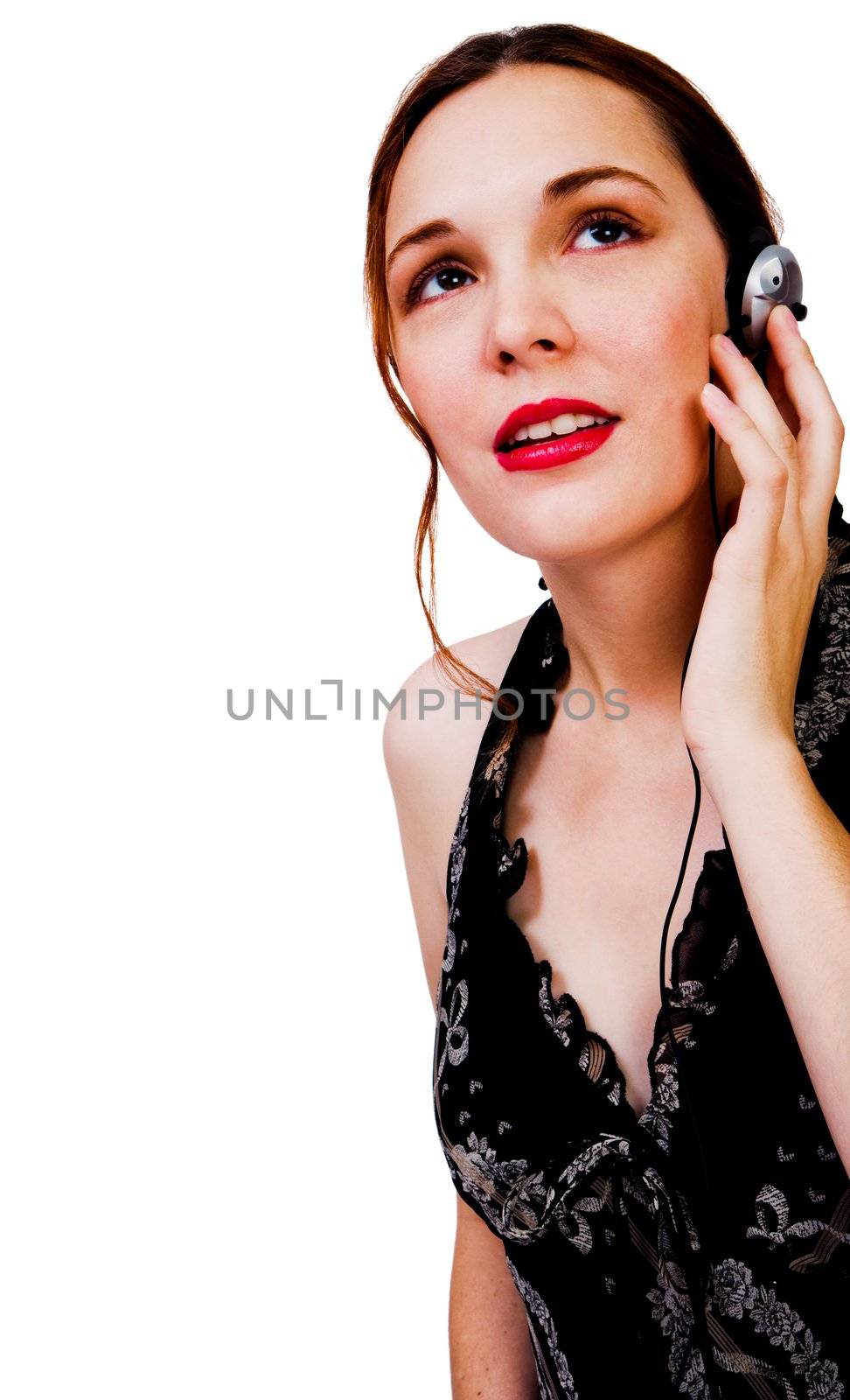 Young woman listening to music on a headphones isolated over white