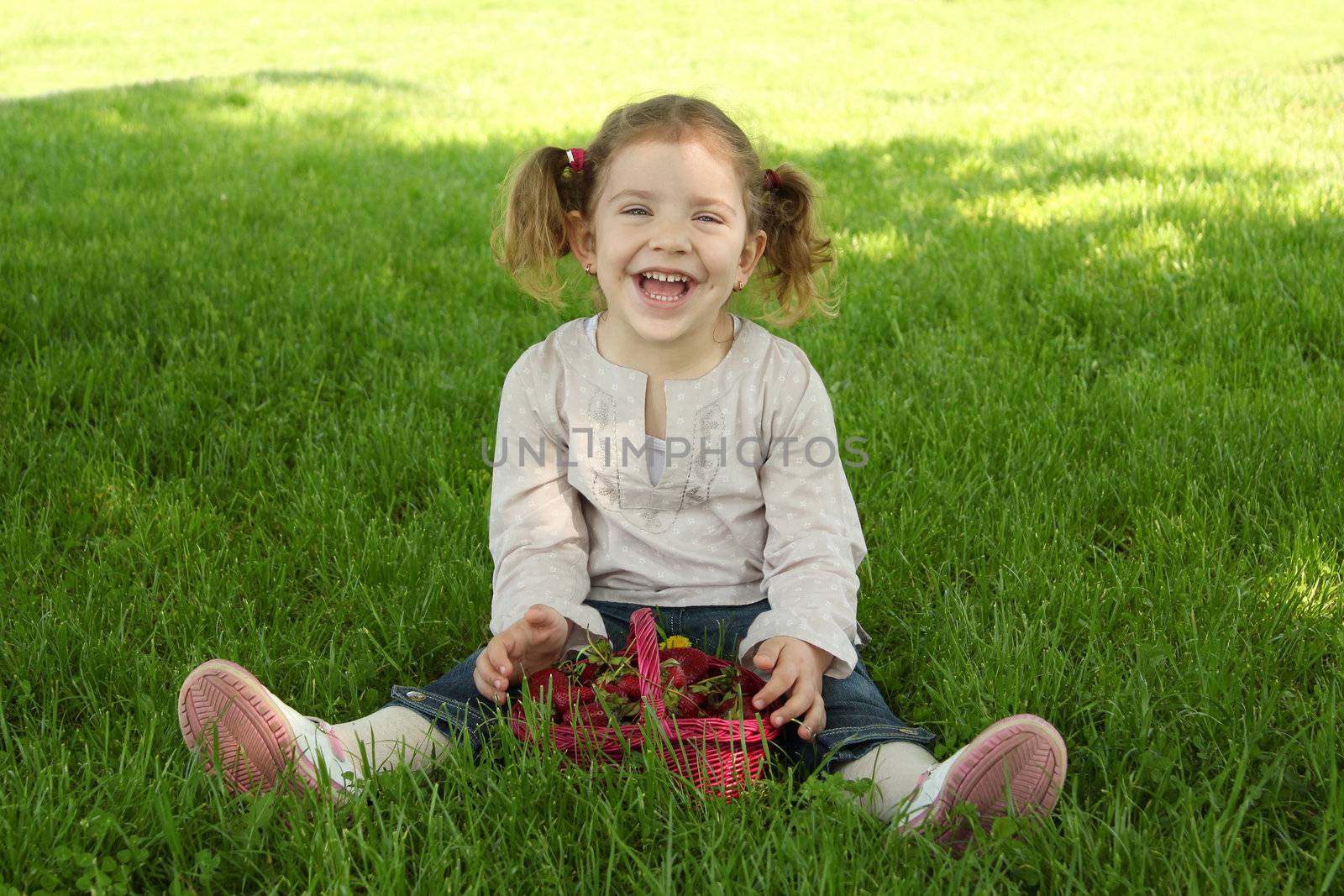 happy young girl sitting on grass in park by goce