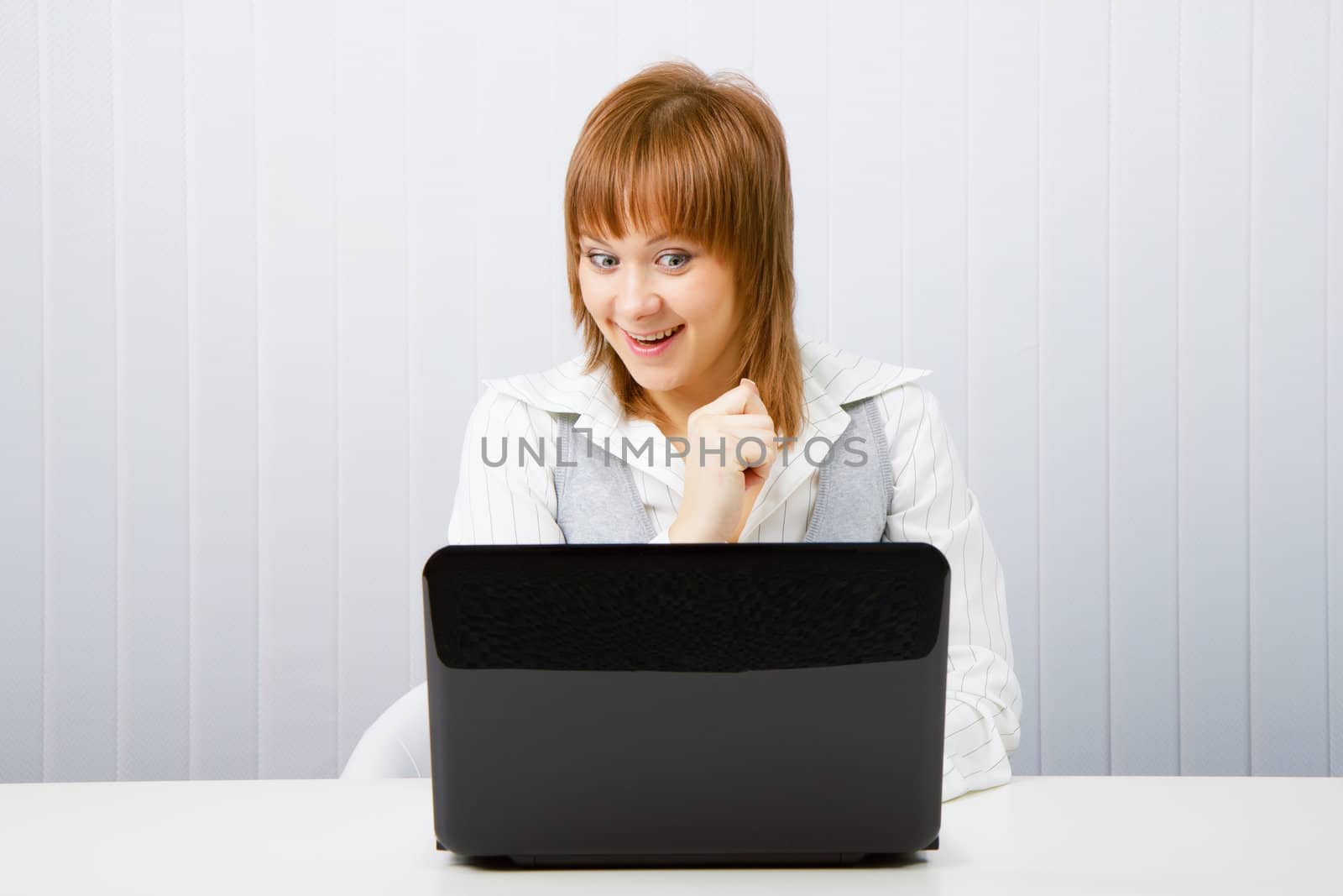 joyful surprise a girl with a laptop in the office

