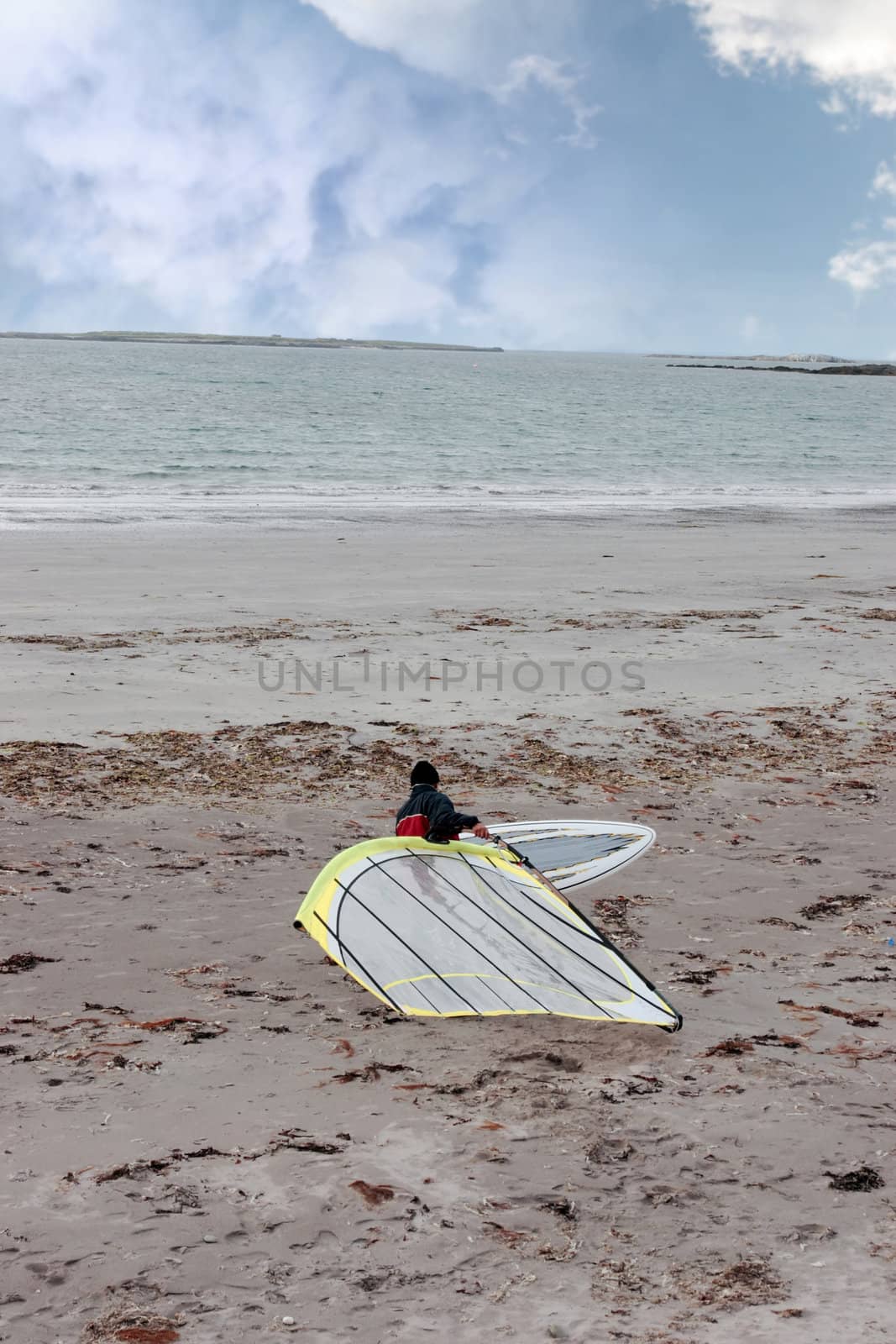 windsurfer getting equipment ready on the beach in the maharees county kerry ireland