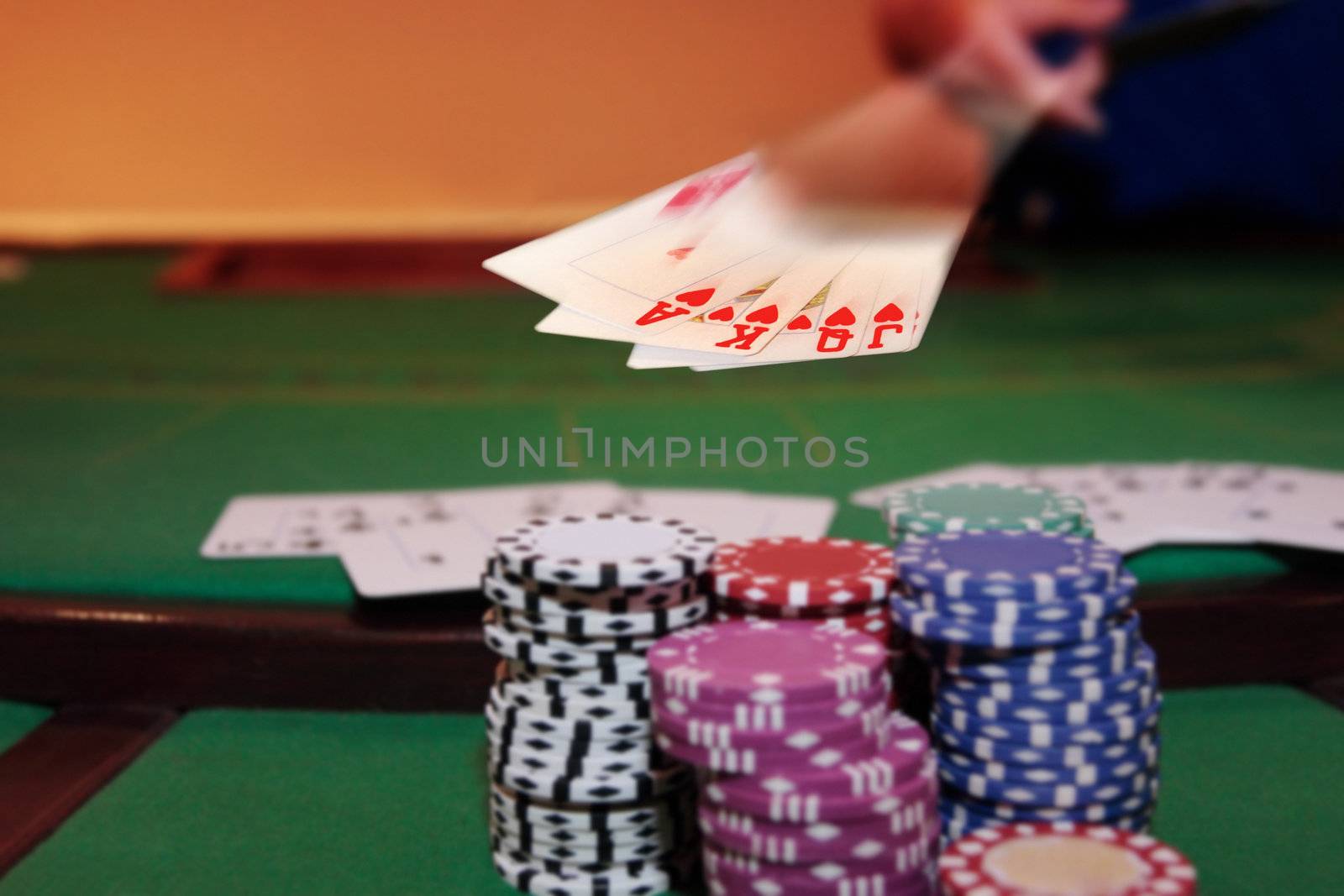 royal flush has poker player showing winning hand of cards with the chips in the foreground