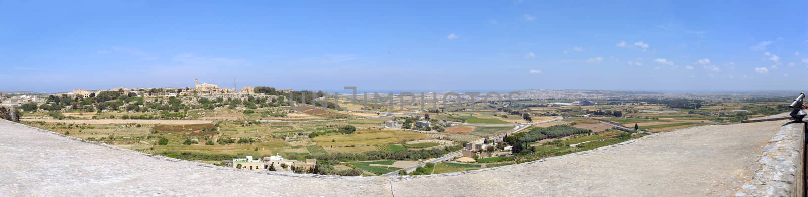 180 degree panoramic image of Maltese countryside and Mosta as seen from Mdina battlements. The image is composed from 13 stitched exposures. In the middle of the sky and airplane goes in for landing.
