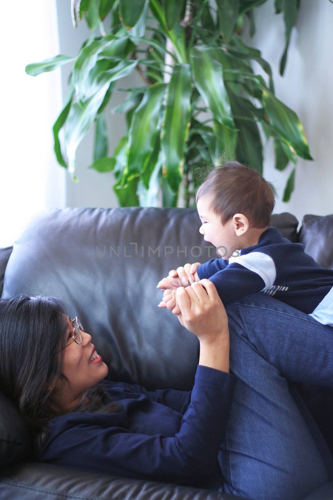 Mother playing with her baby boy on couch