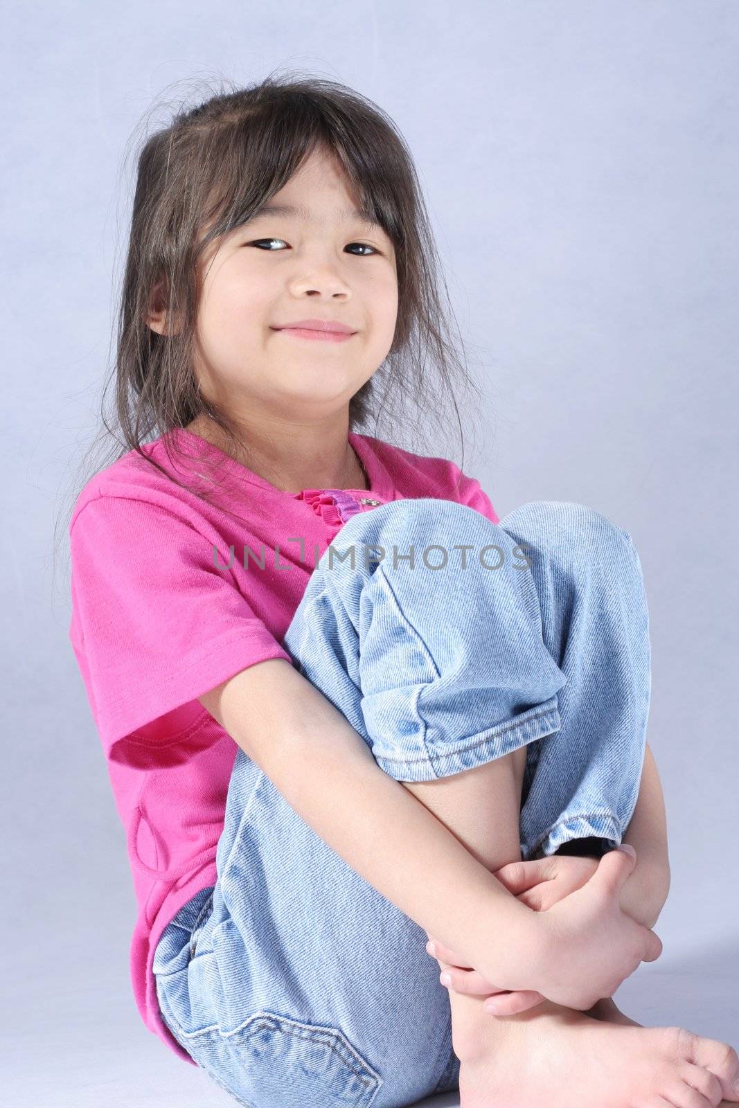 Little girl relaxing with arms around knees