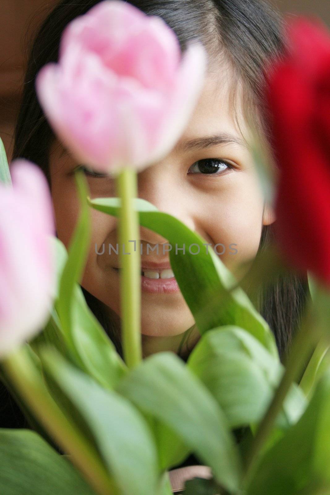 Child peeking through tulips by jarenwicklund