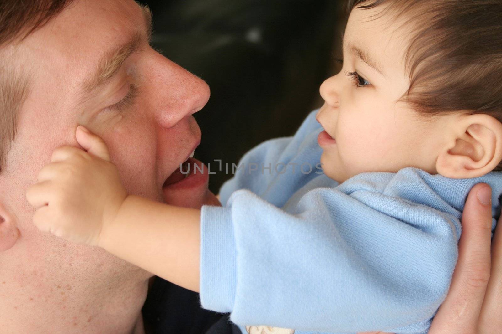 Baby tenderly touching dad's face