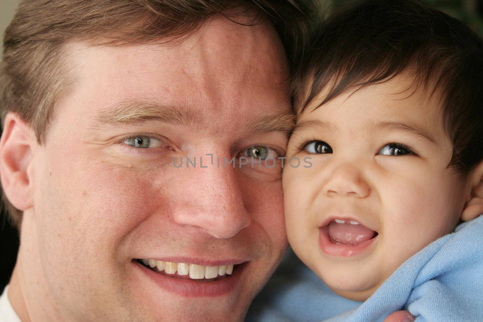 Father son cheek to cheek. Father is Scandinavian, baby is multiracial