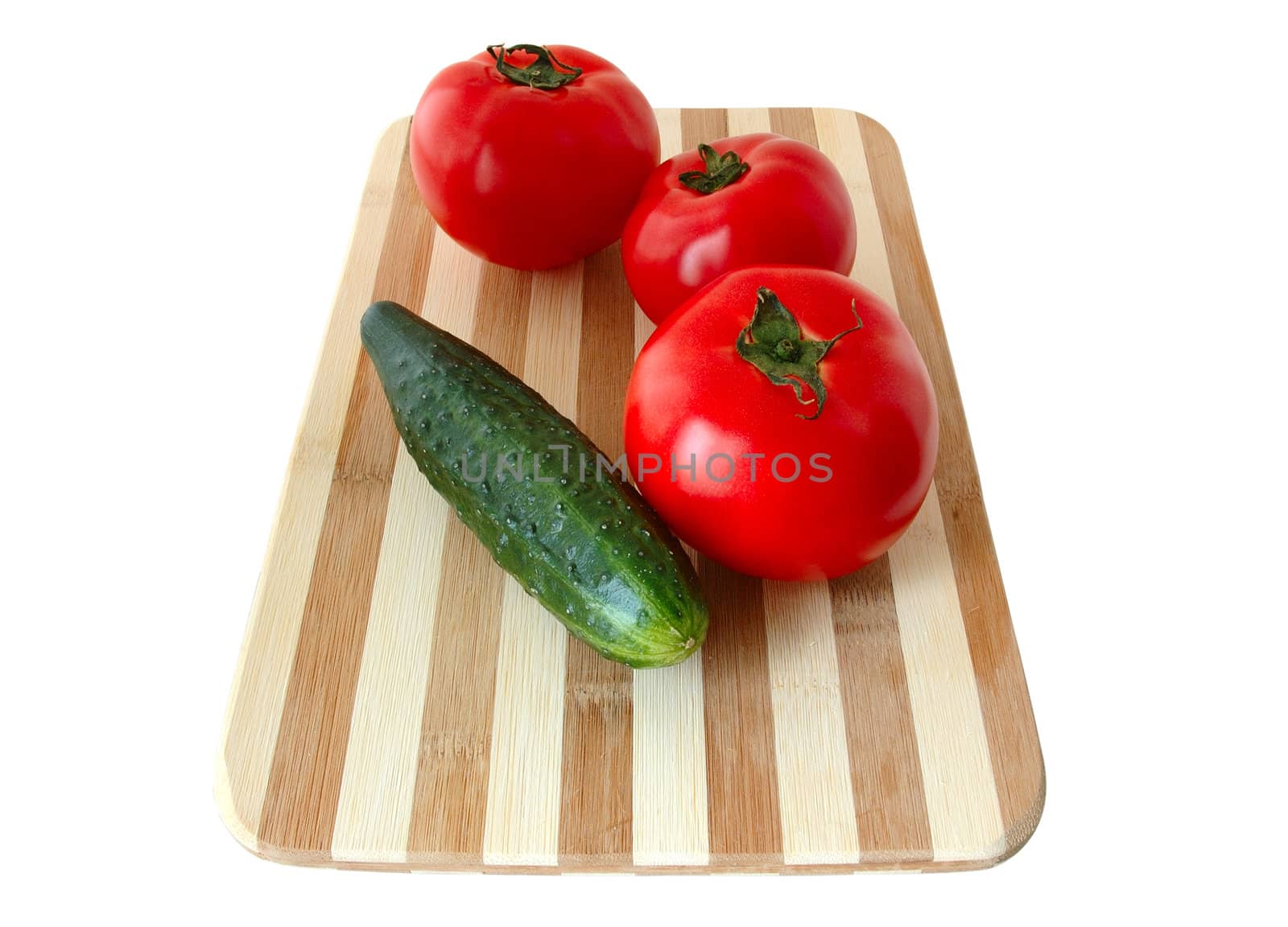 Vegetables (tomatos and cucumber) on bamboo cutting board.