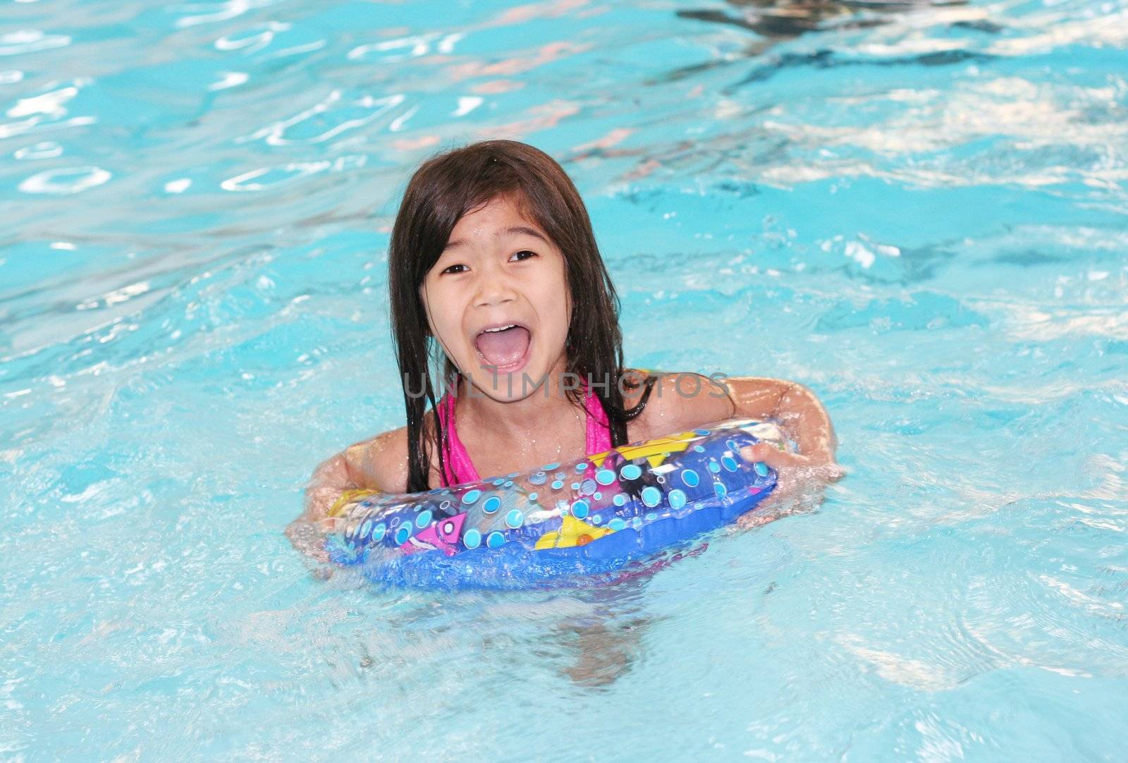 Child enjoying her swimming time in the pool.