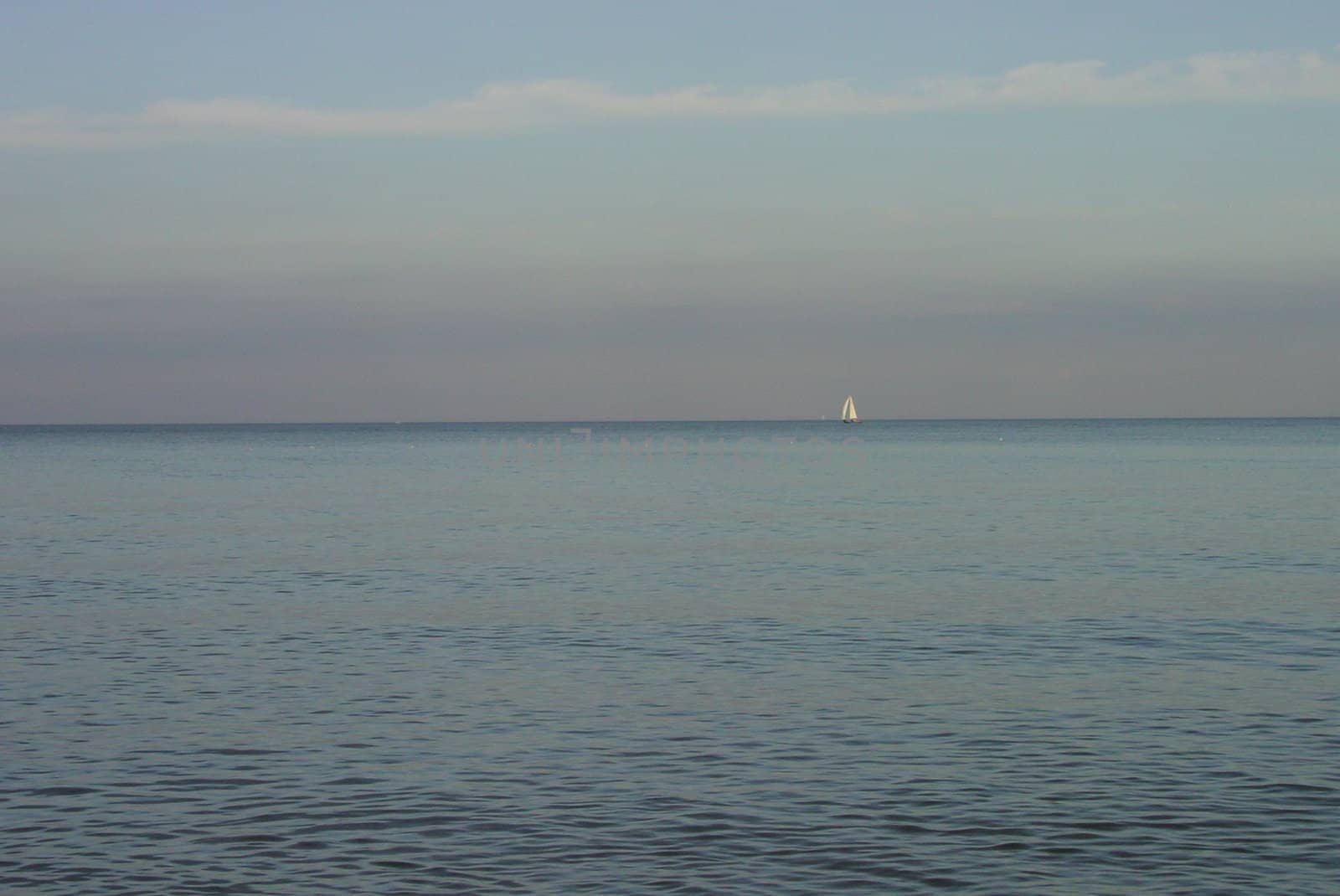 Small white sail on pastel silent sea