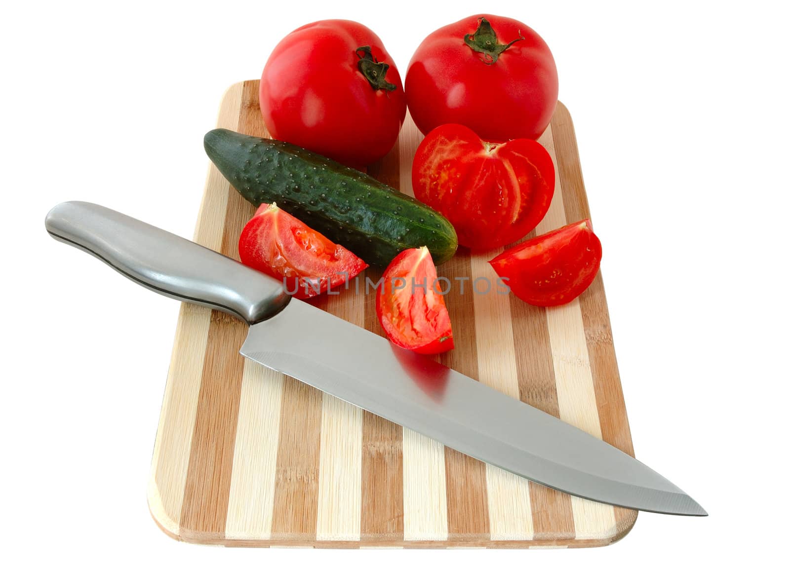 Vegetables (tomatos and cucumber) with knife on bamboo cutting board.