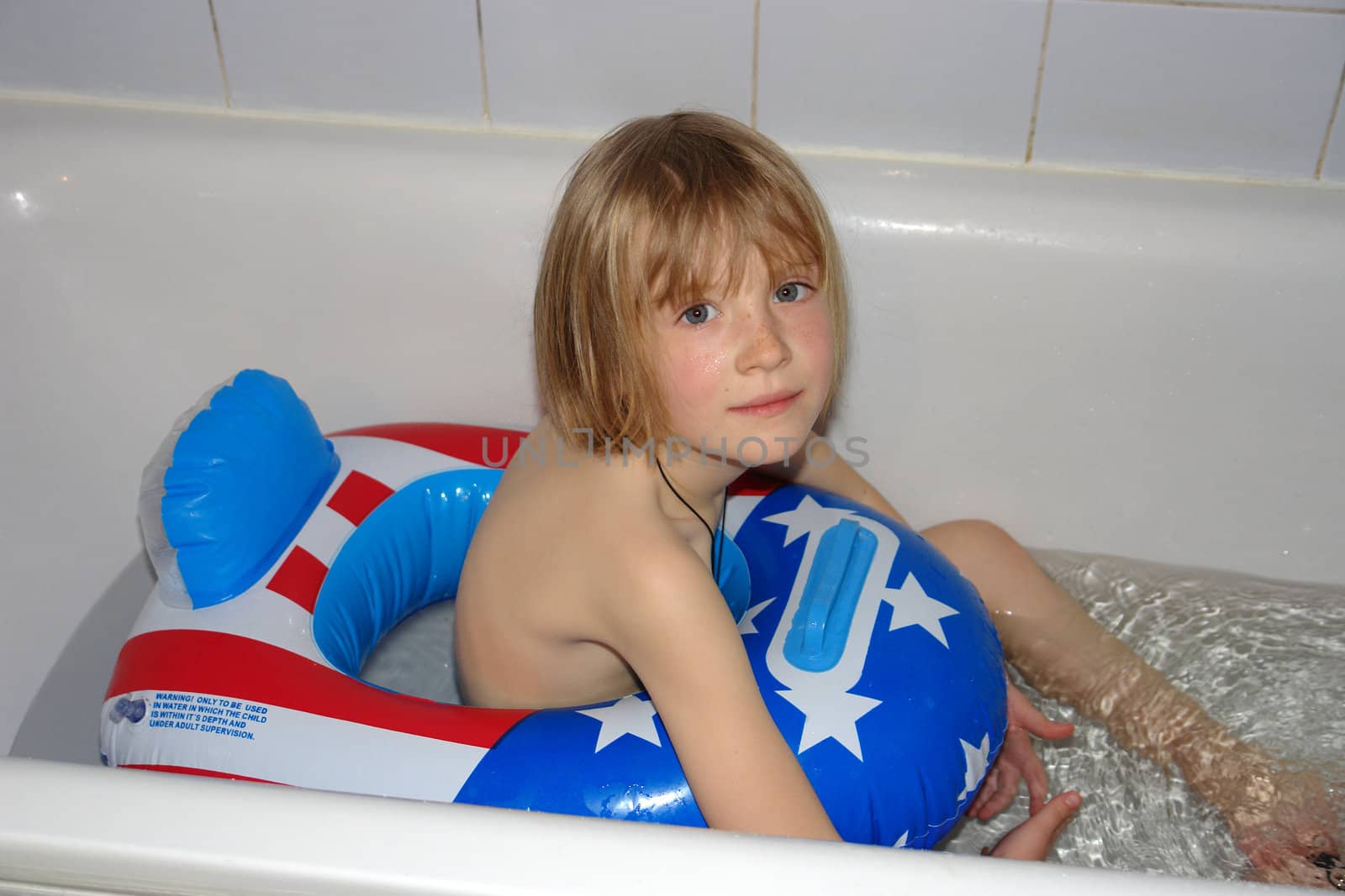 The girl, floats in pool with a life buoy