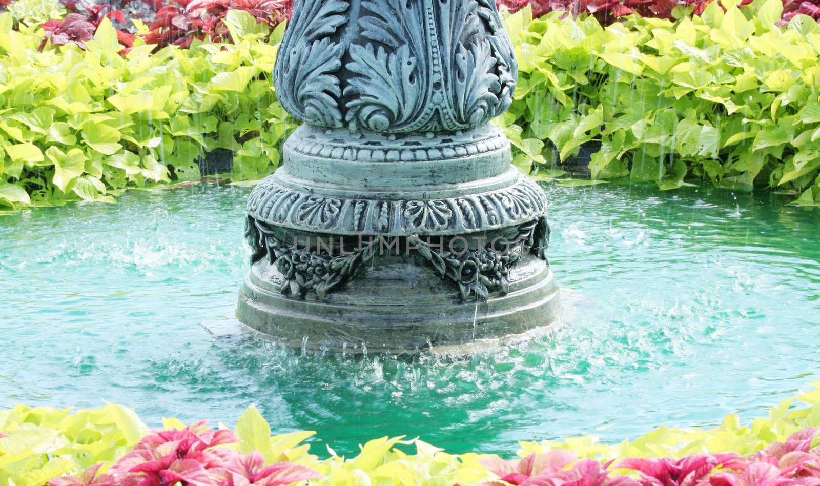 Beautiful and colorful water fountain surounded by plants