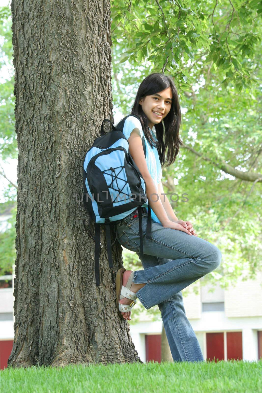 Young teen girl standing with backpack by tree, by jarenwicklund