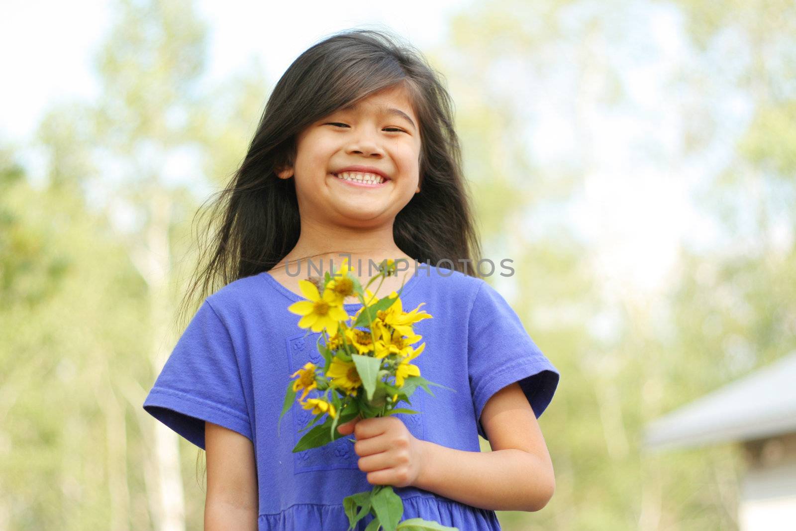 Adorable six year old Girl holding bouquet of sunflowers