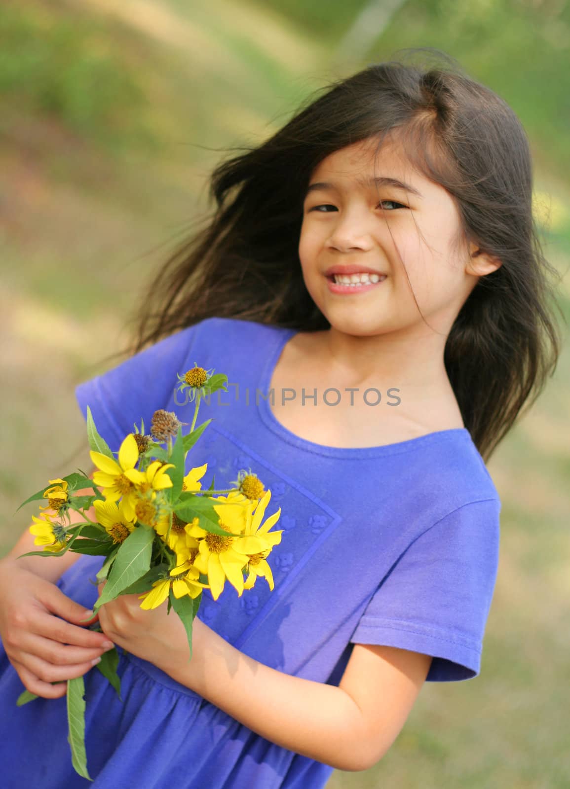 Adorable six year old Girl holding bouquet of sunflowers