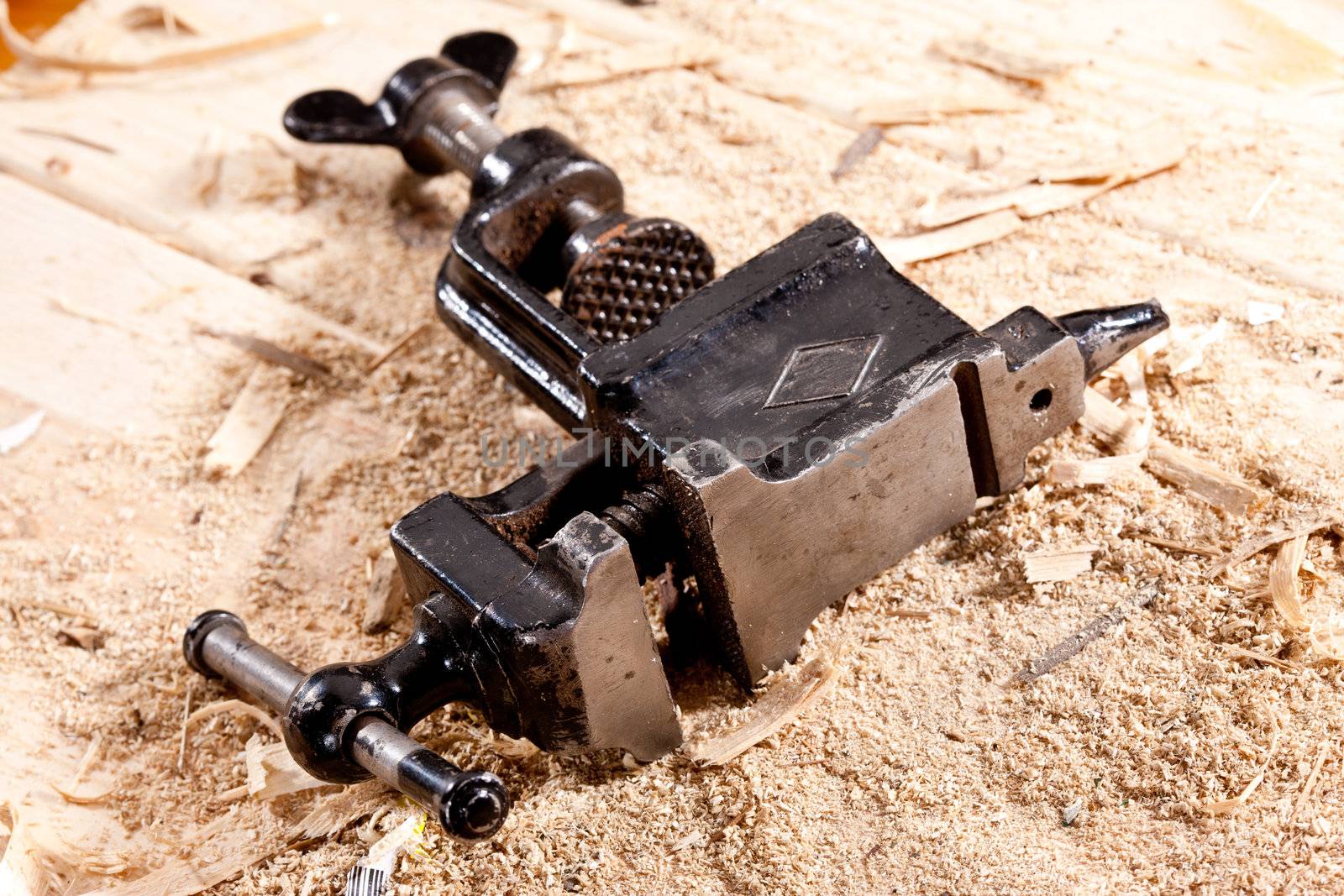 tools series: steel black grip vice on sawdust table