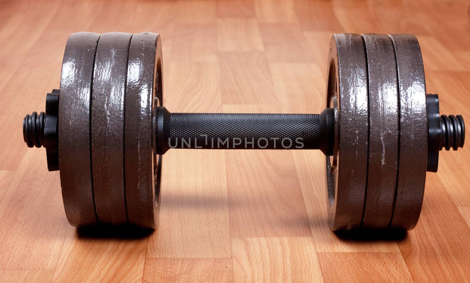 Single heavy dumbbell on a floor