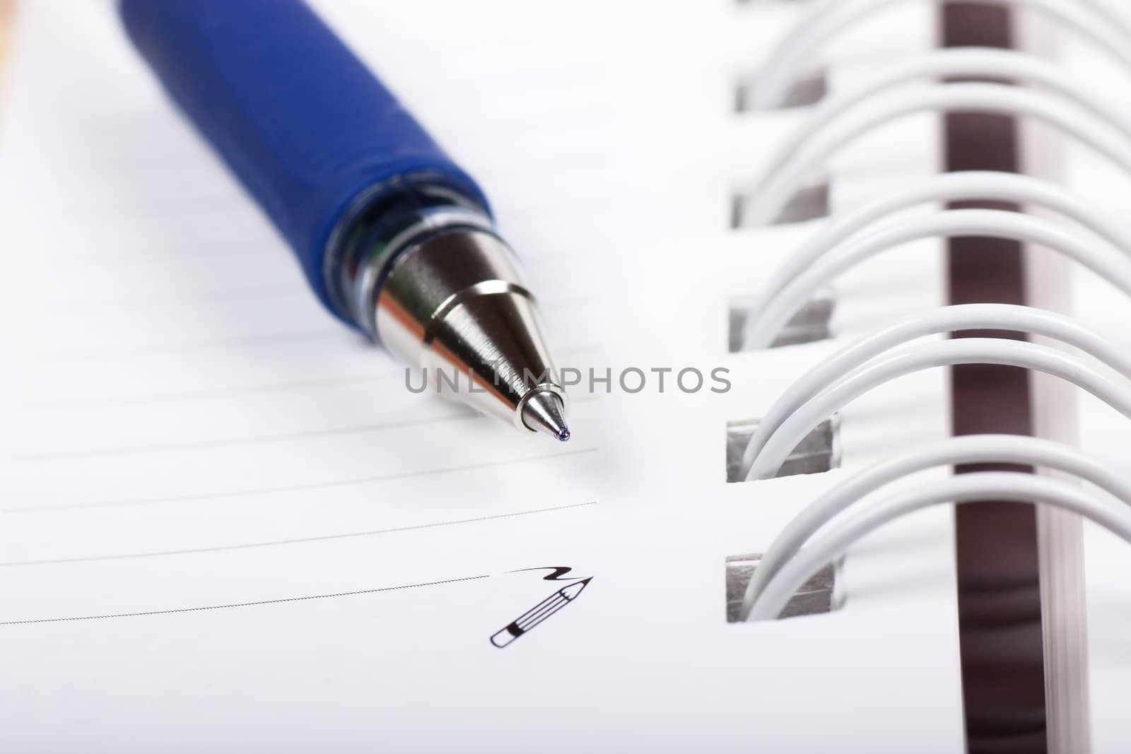 Macro view of blank spiral notebook and pen