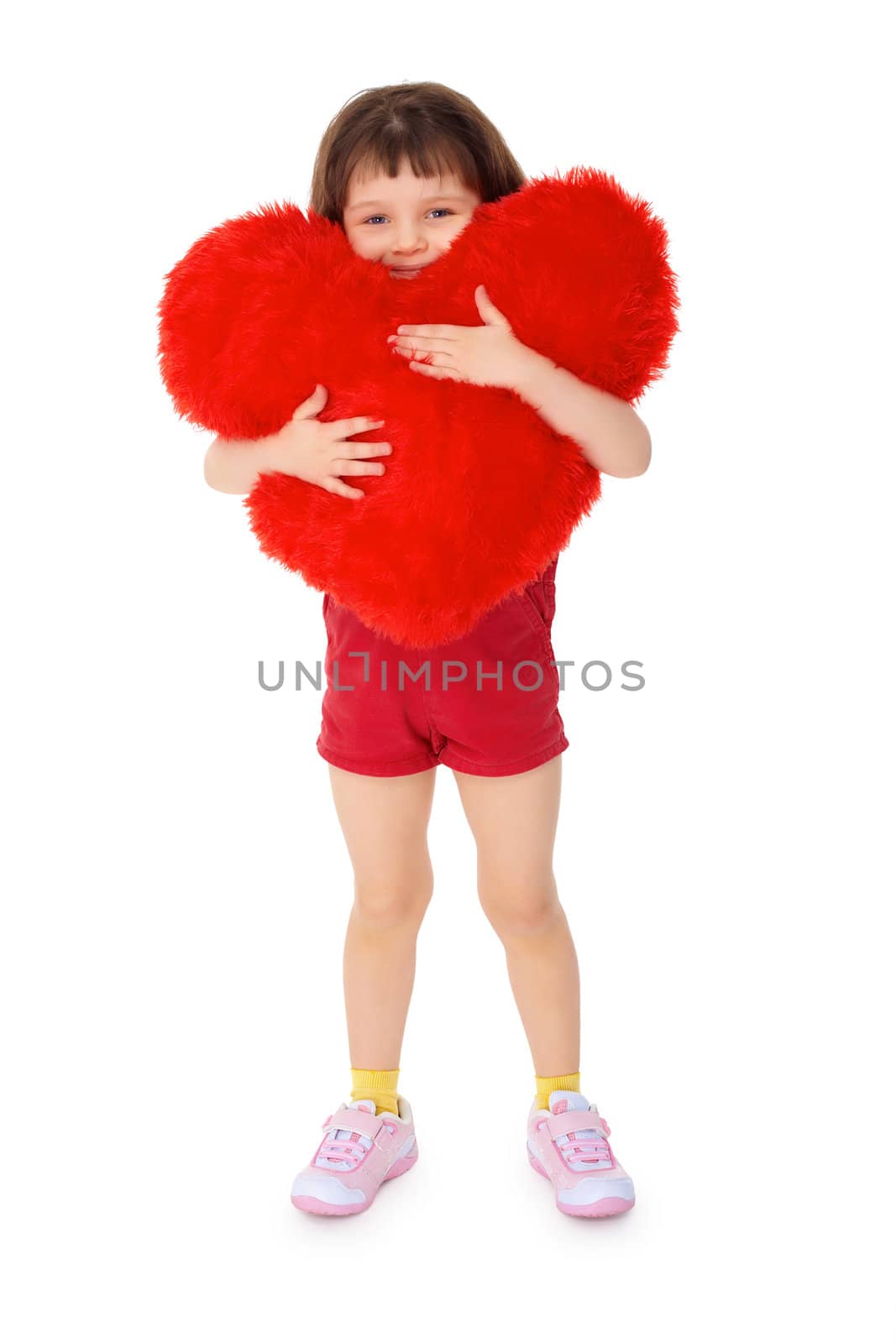 Little girl hugging a toy heart, isolated on a white background