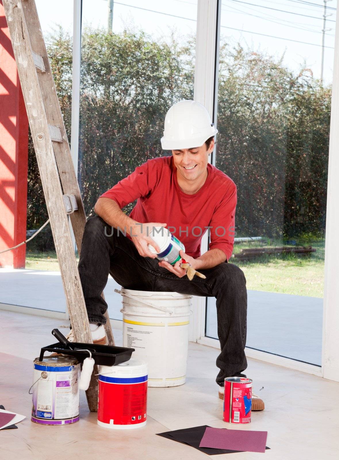 A man with a hard hat, indoors ready to paint