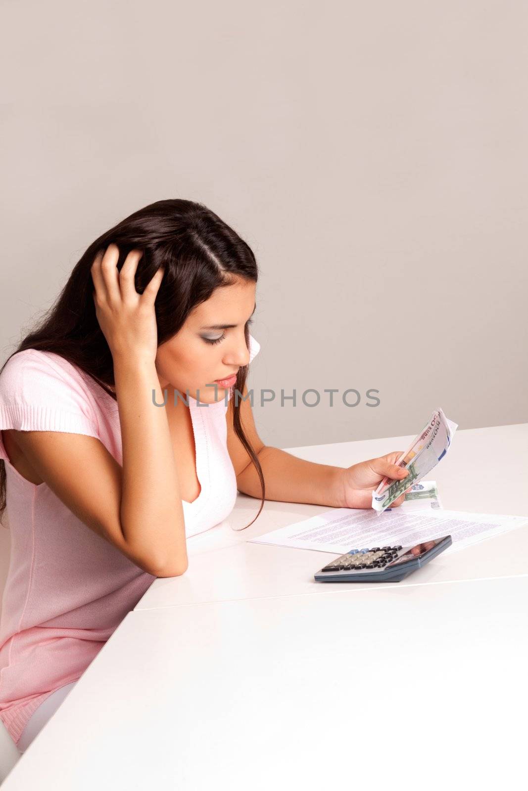A worried woman counting money and planning a budget