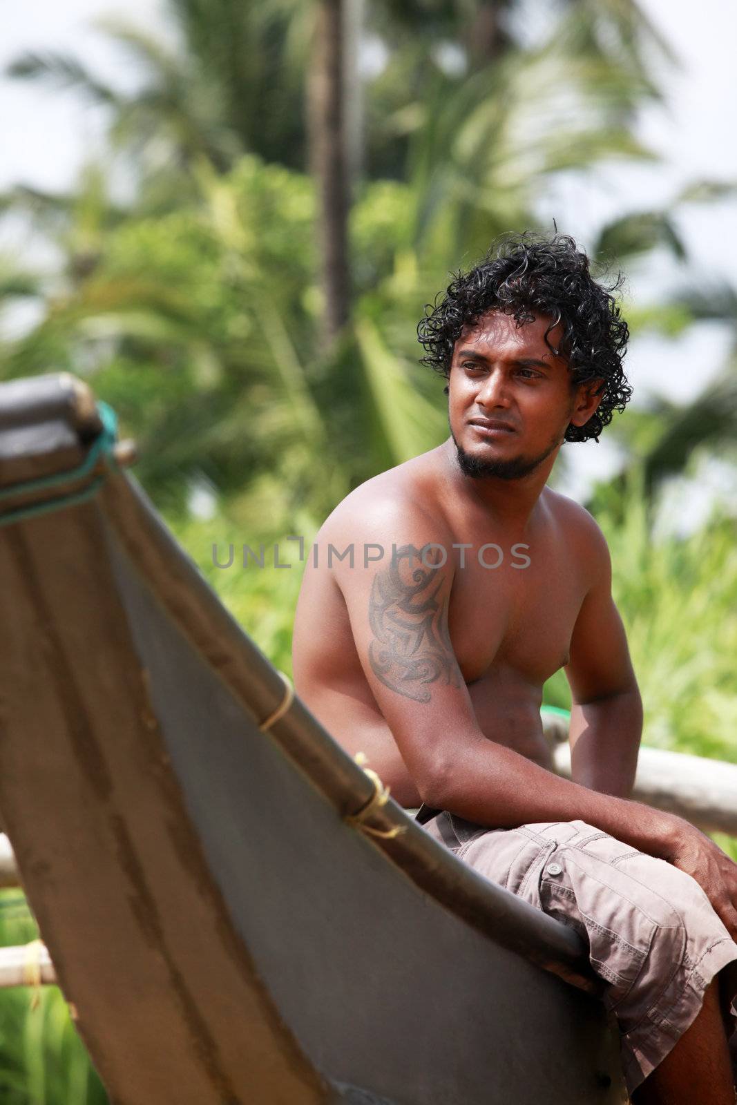 The young man sitting by a boat. Sri Lanka