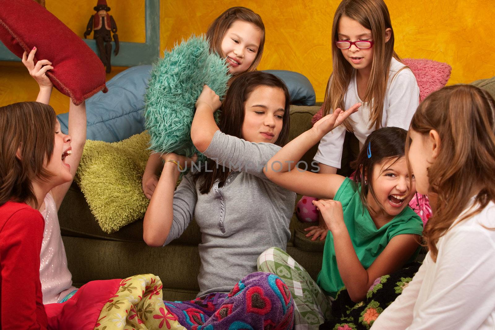Group of little girls hitting each other with pillows