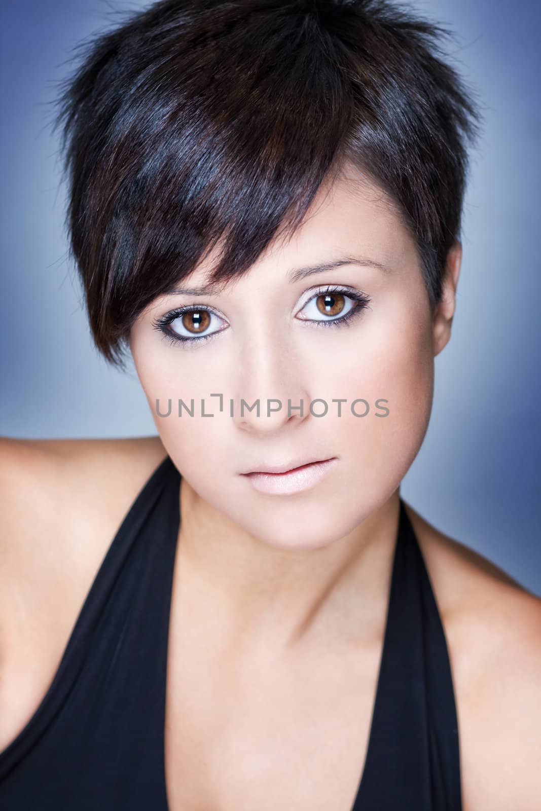 Fashion portrait of a beautiful woman with short hair. Blue background.