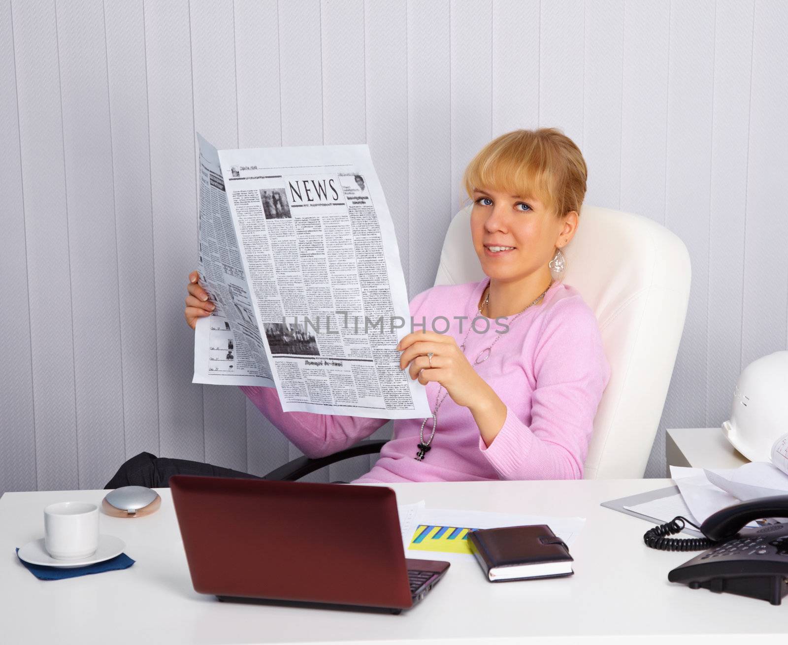 Young woman reads news on the workplace by pzaxe