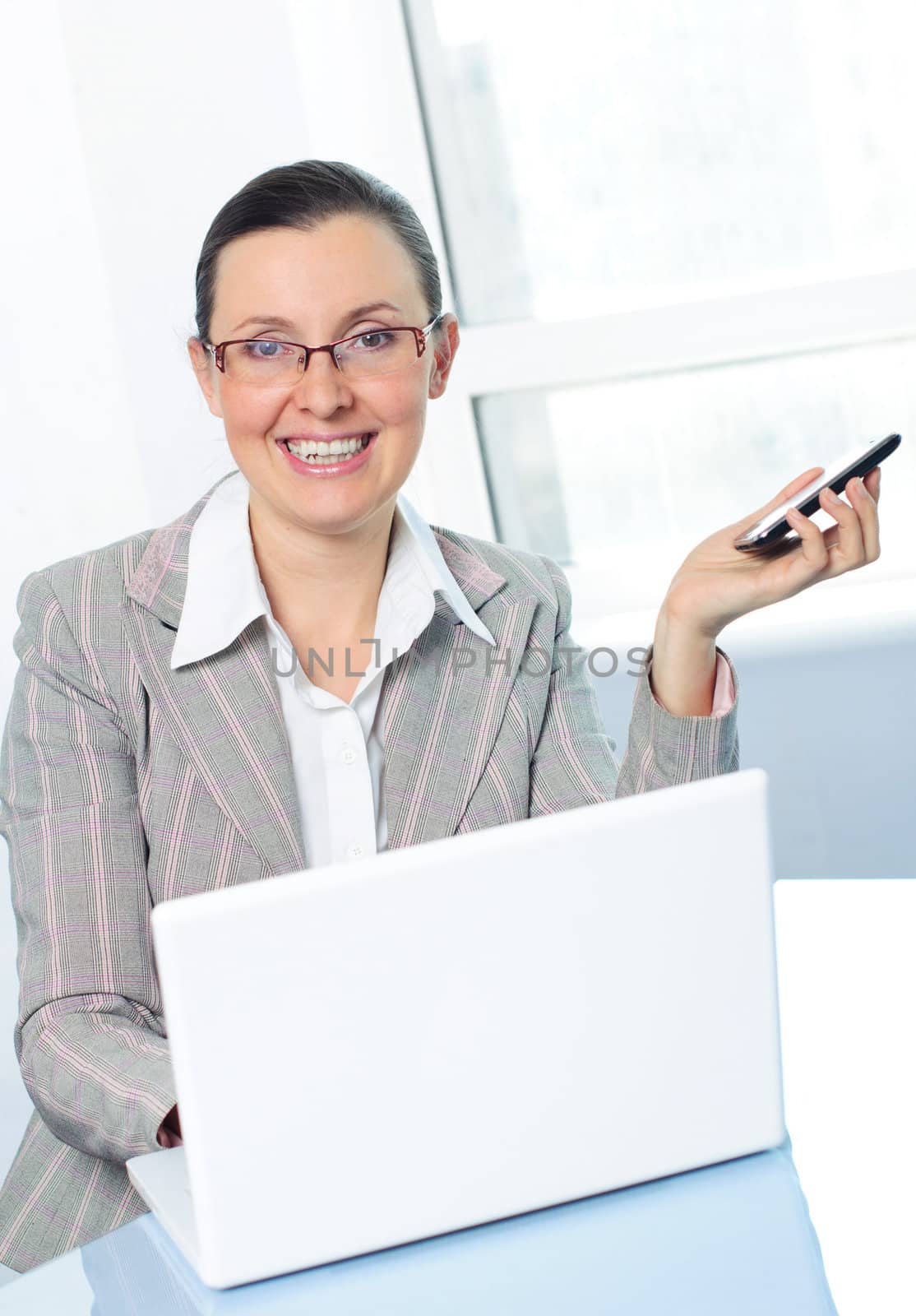 smiling young business woman with glasses using laptop by maxoliki
