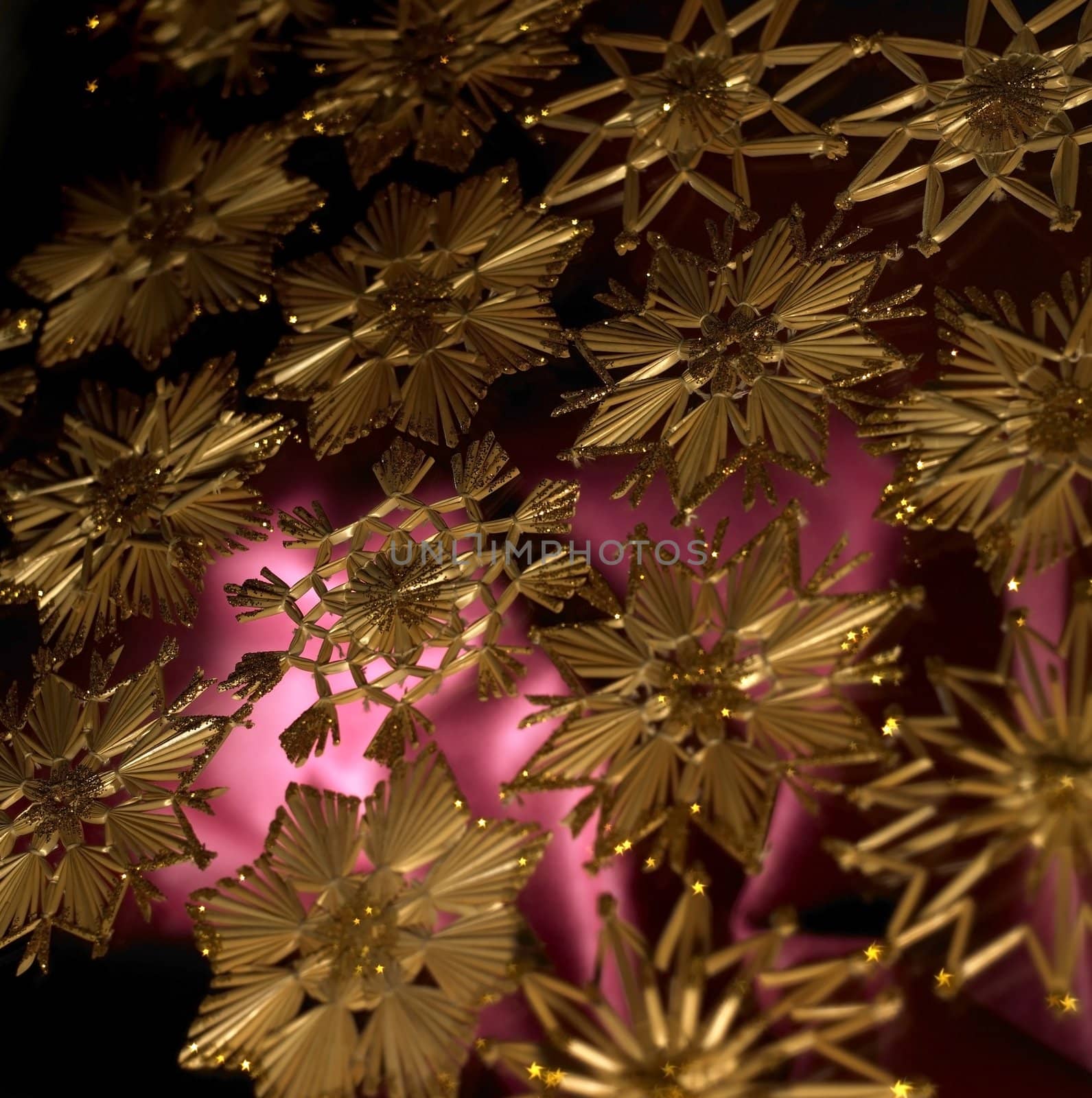 full frame studio photography showing a christmas background with red fabrics and gold toned straw stars
