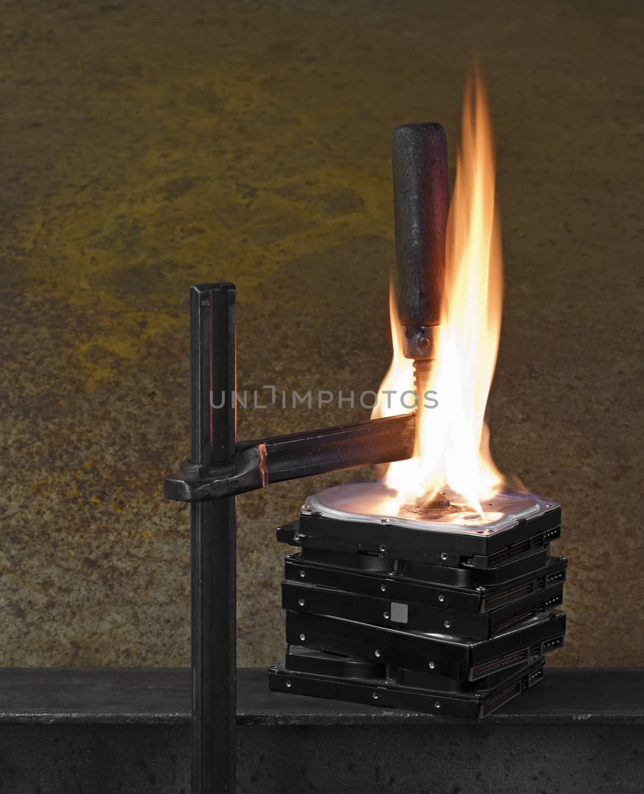flames on stack of pressed hard drives. pressed by clamp