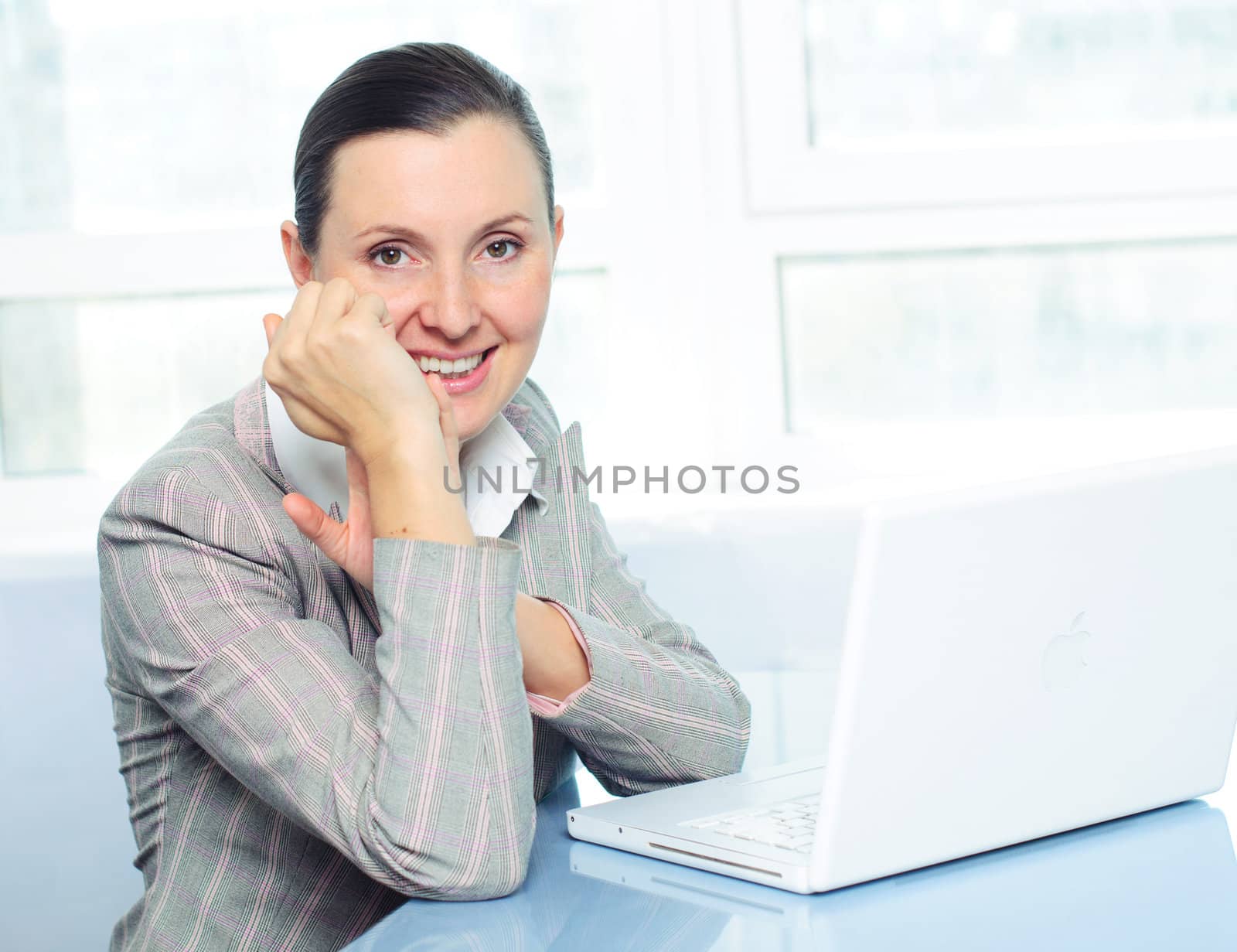 smiling young business woman using laptop by maxoliki