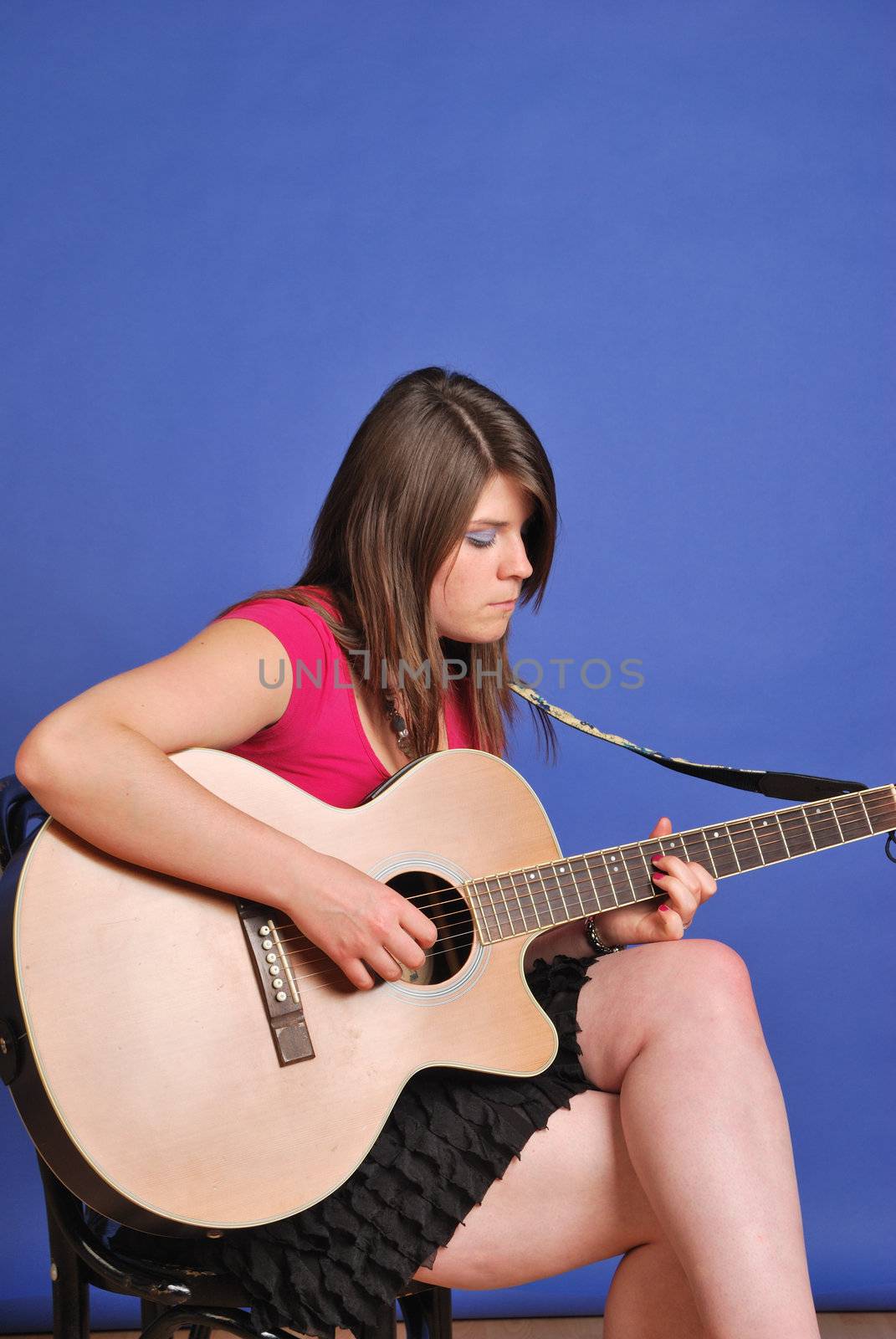 young girl playing acoustic guitar