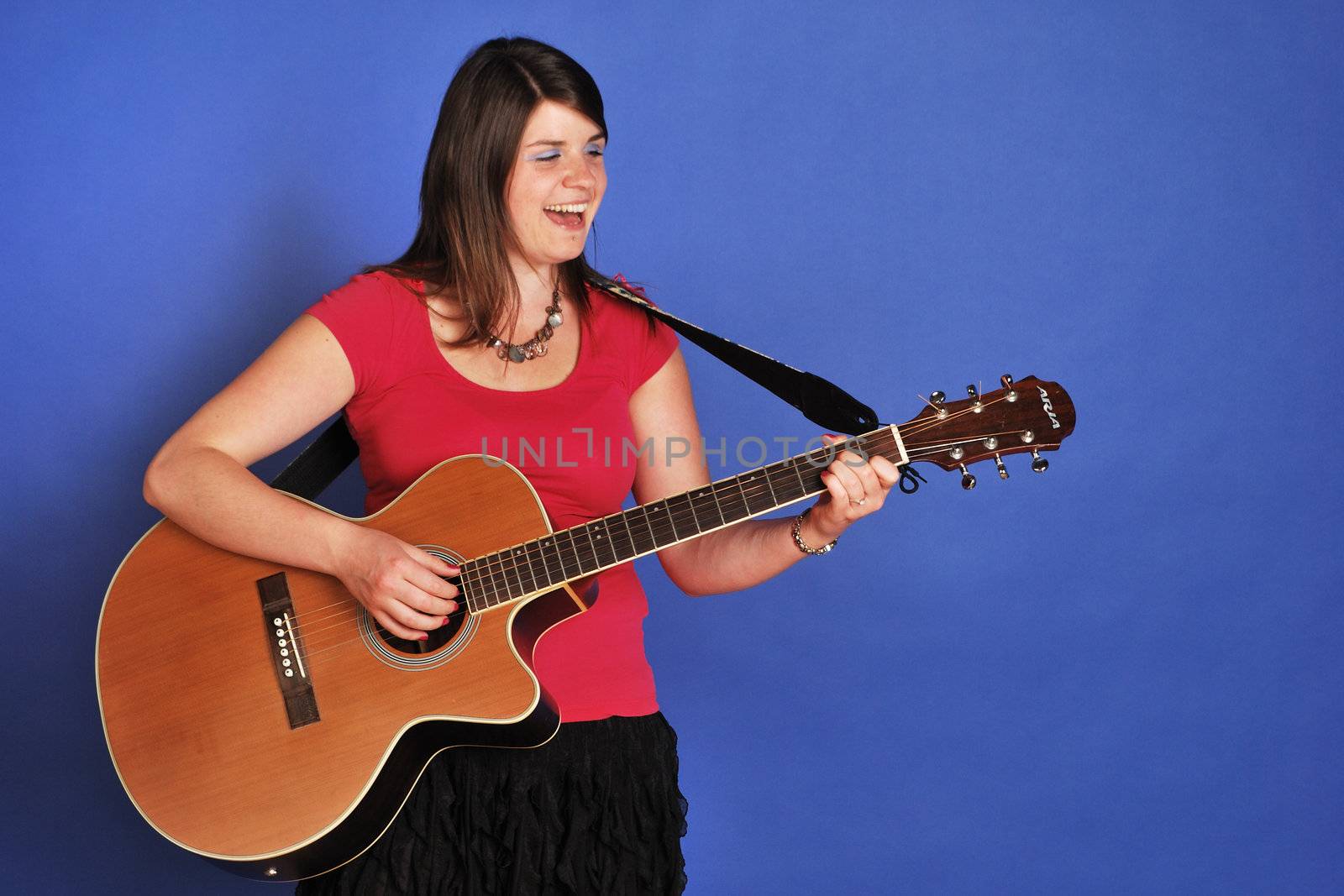 pretty girl playing on acoustic guitar
