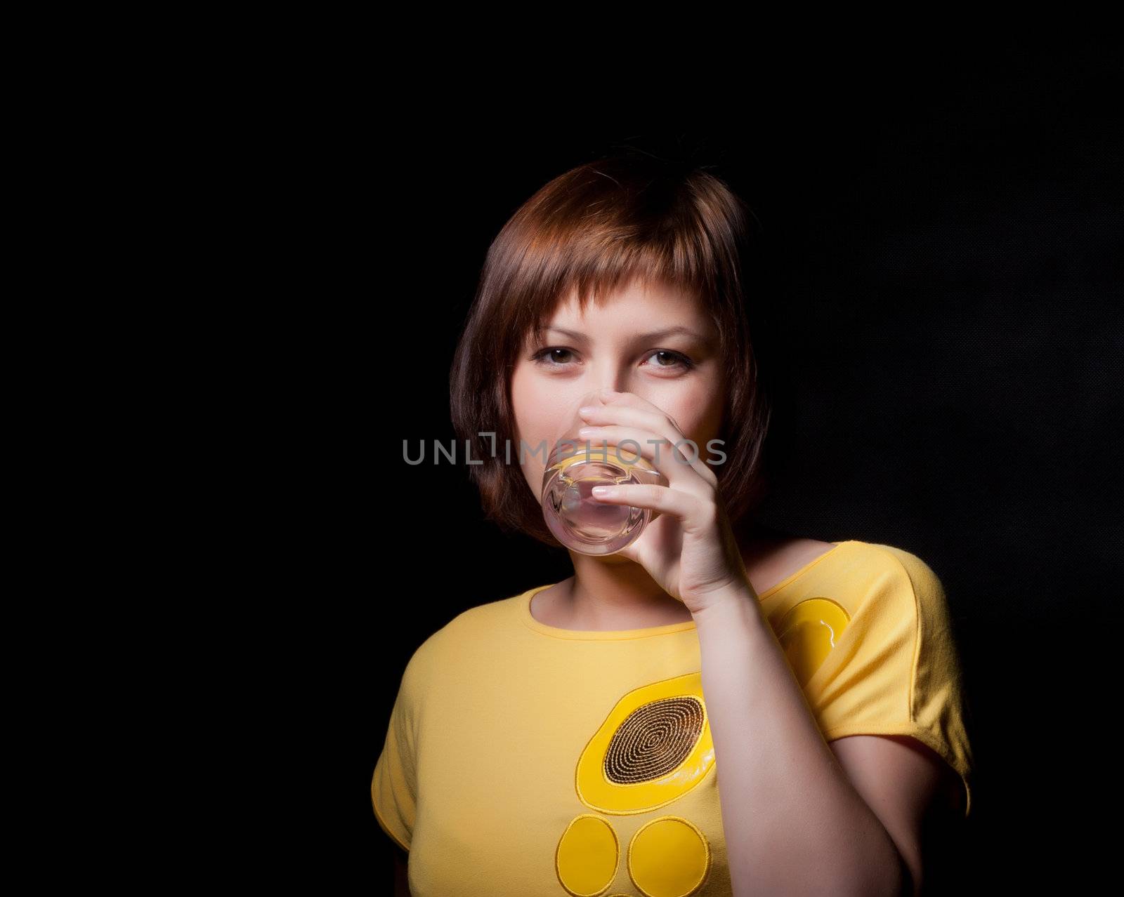 young woman with glass water, black background