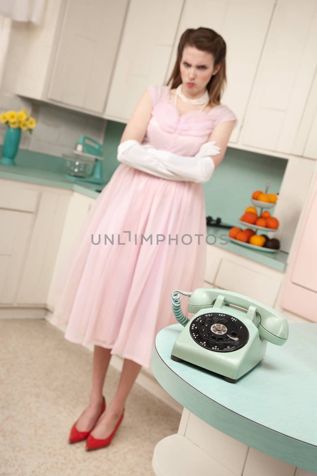 Unhappy cute young woman bride waiting by telephone